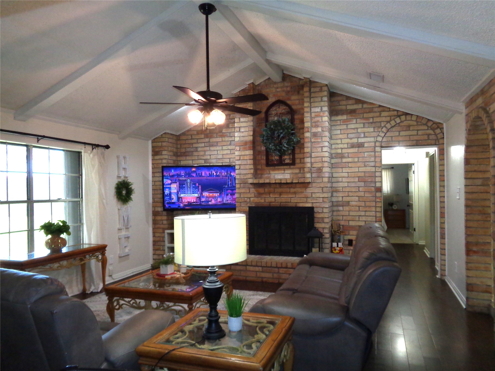 Family room with wood burning fireplace and vaulted ceiling.