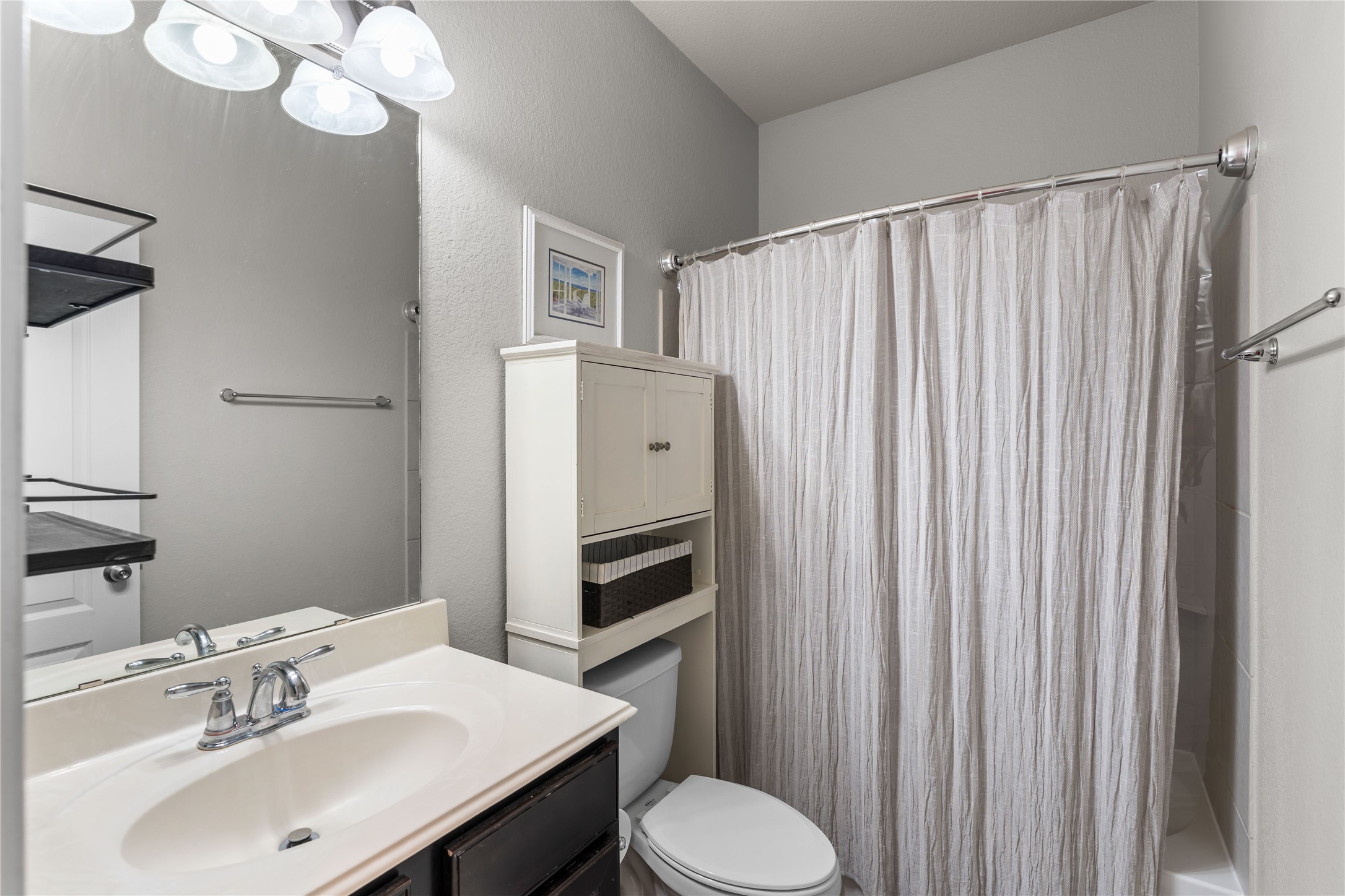 Full secondary bathroom with vanity and tub/shower combination.