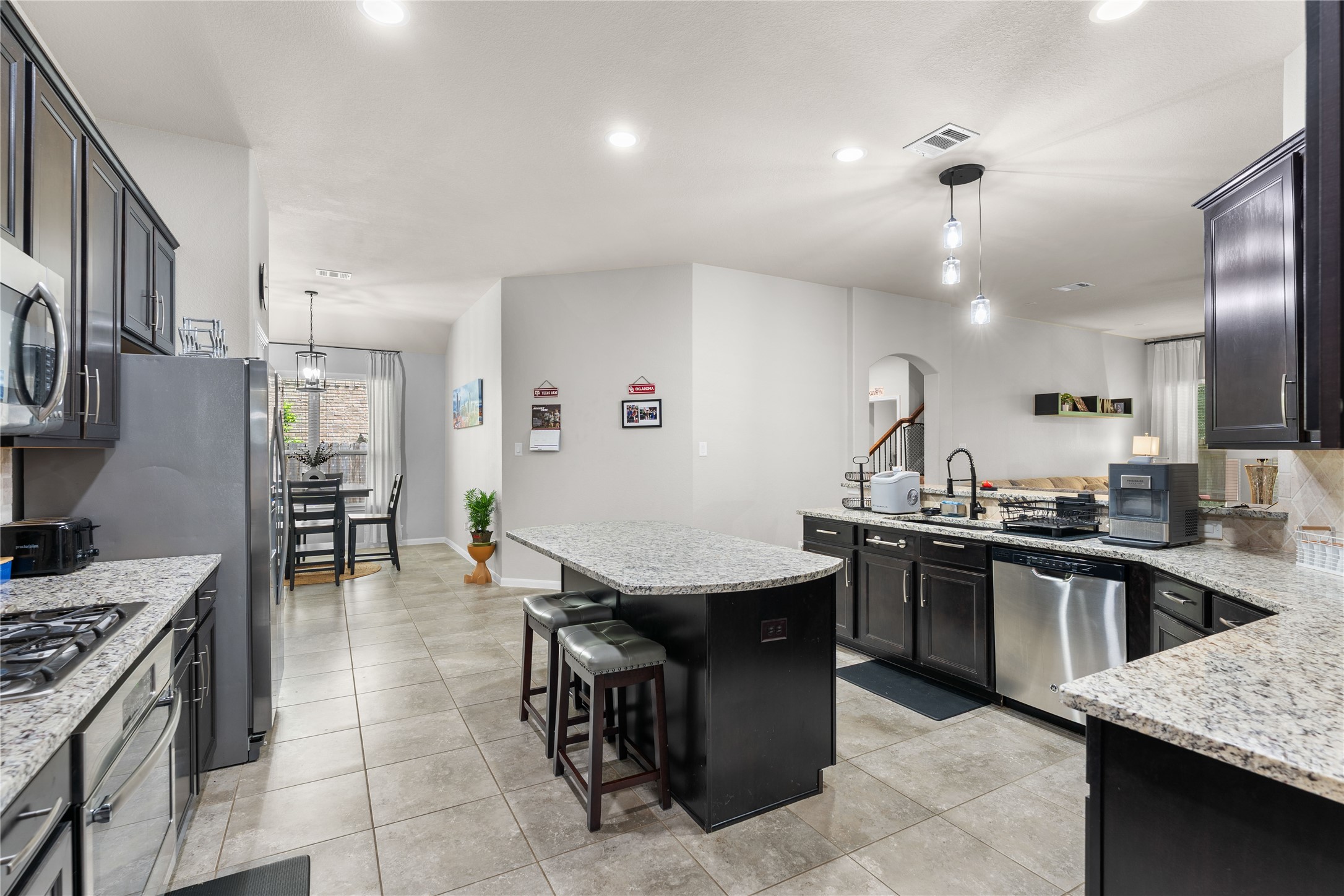 Open-concept kitchen featuring granite countertops, generous prep space, and bar seating. Open-concept kitchen featuring granite countertops, generous prep space, and bar seating.