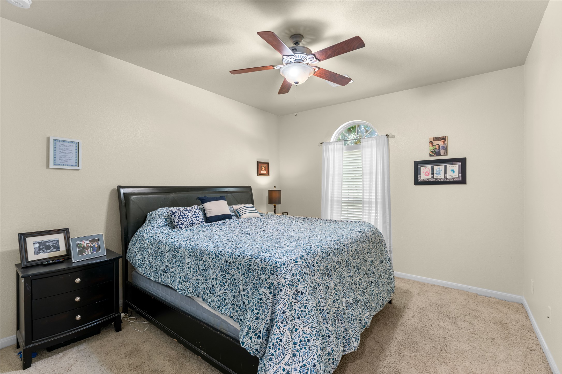 Secondary bedroom with neutral finishes and ceiling fan.