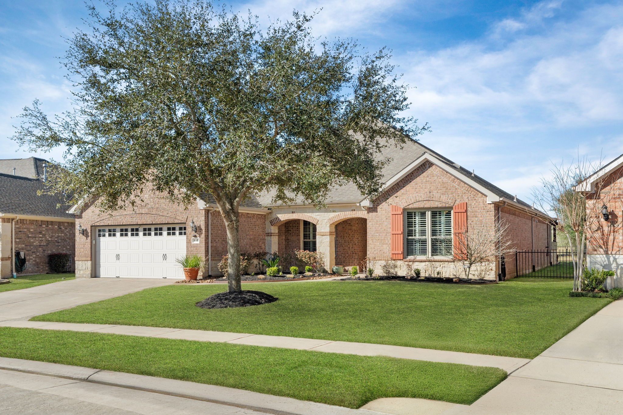 Lovely single-story home with a stone facade and arched entryway, complemented by mature shrubs and a manicured lawn. Lovely single-story home with a stone facade and arched entryway, complemented by mature shrubs and a manicured lawn.