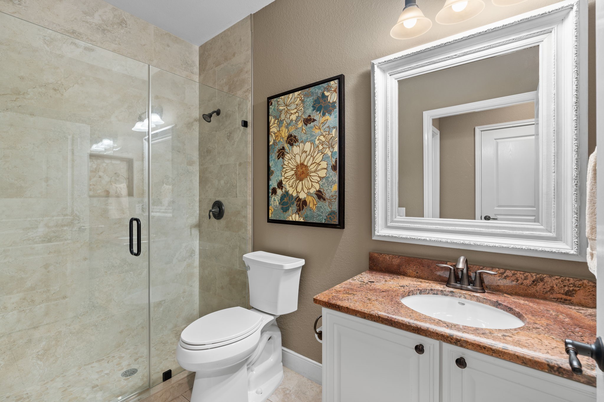 The tile in the guest bath was installed all the way to the ceiling. Beautiful white framed mirror -