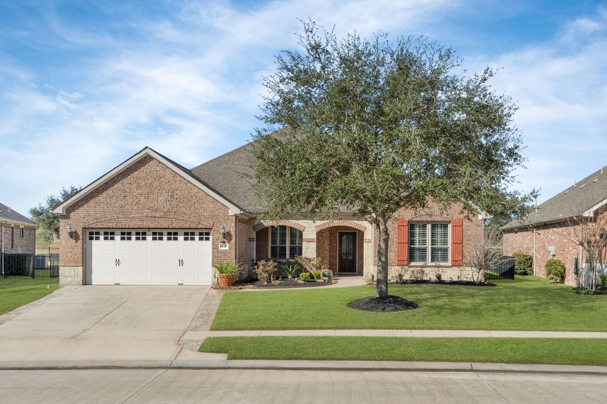 Charming architectural design featuring a blend of brick and stone, with two graceful arches framed by a stunning oak tree! Charming architectural design featuring a blend of brick and stone, with two graceful arches framed by a stunning oak tree!