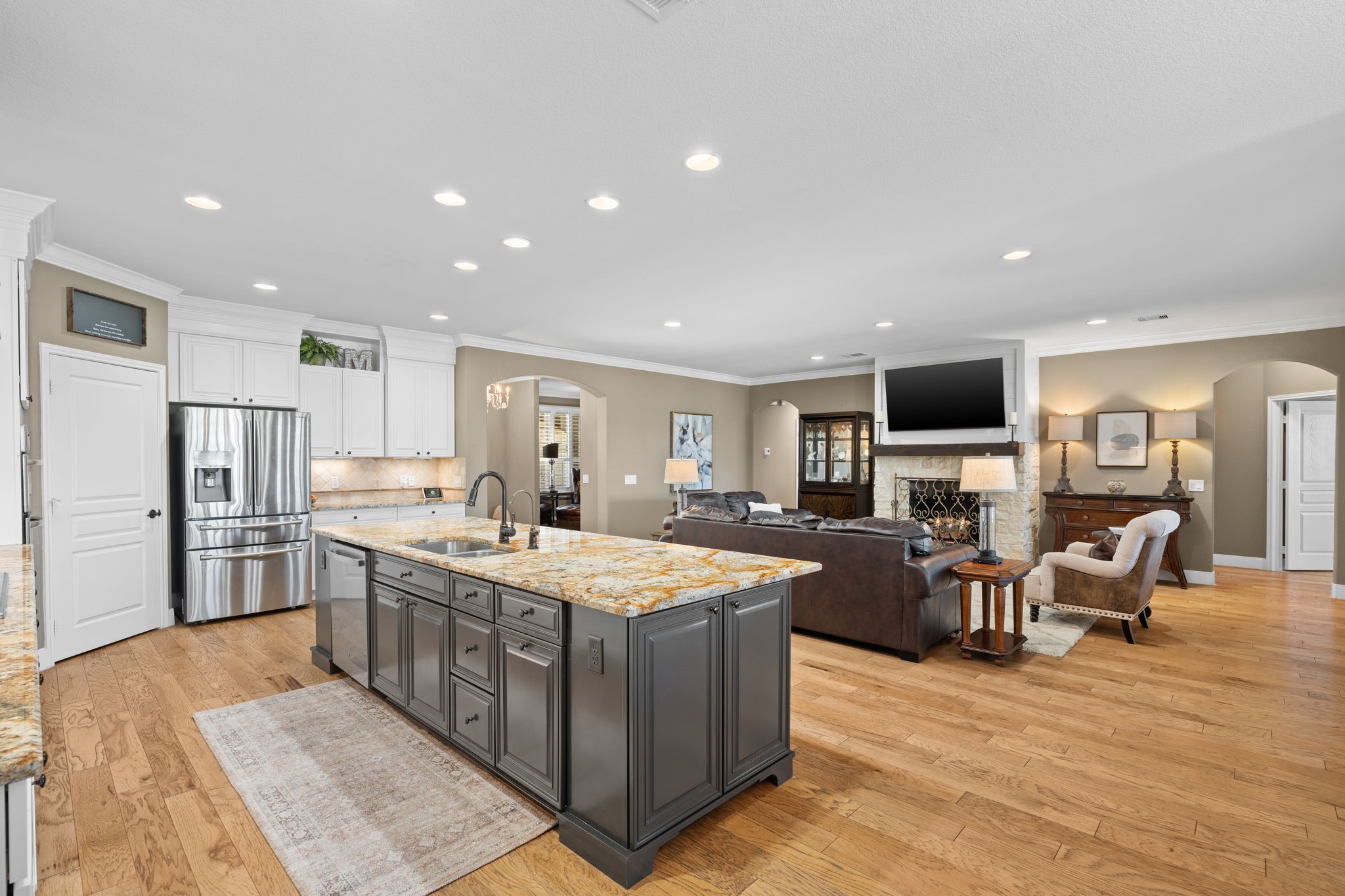 Beautiful wood flooring graces this exquisite home. As you step into this inviting space, you'll notice the seamless flow from the gathering area, through the dining room, and into the kitchen.