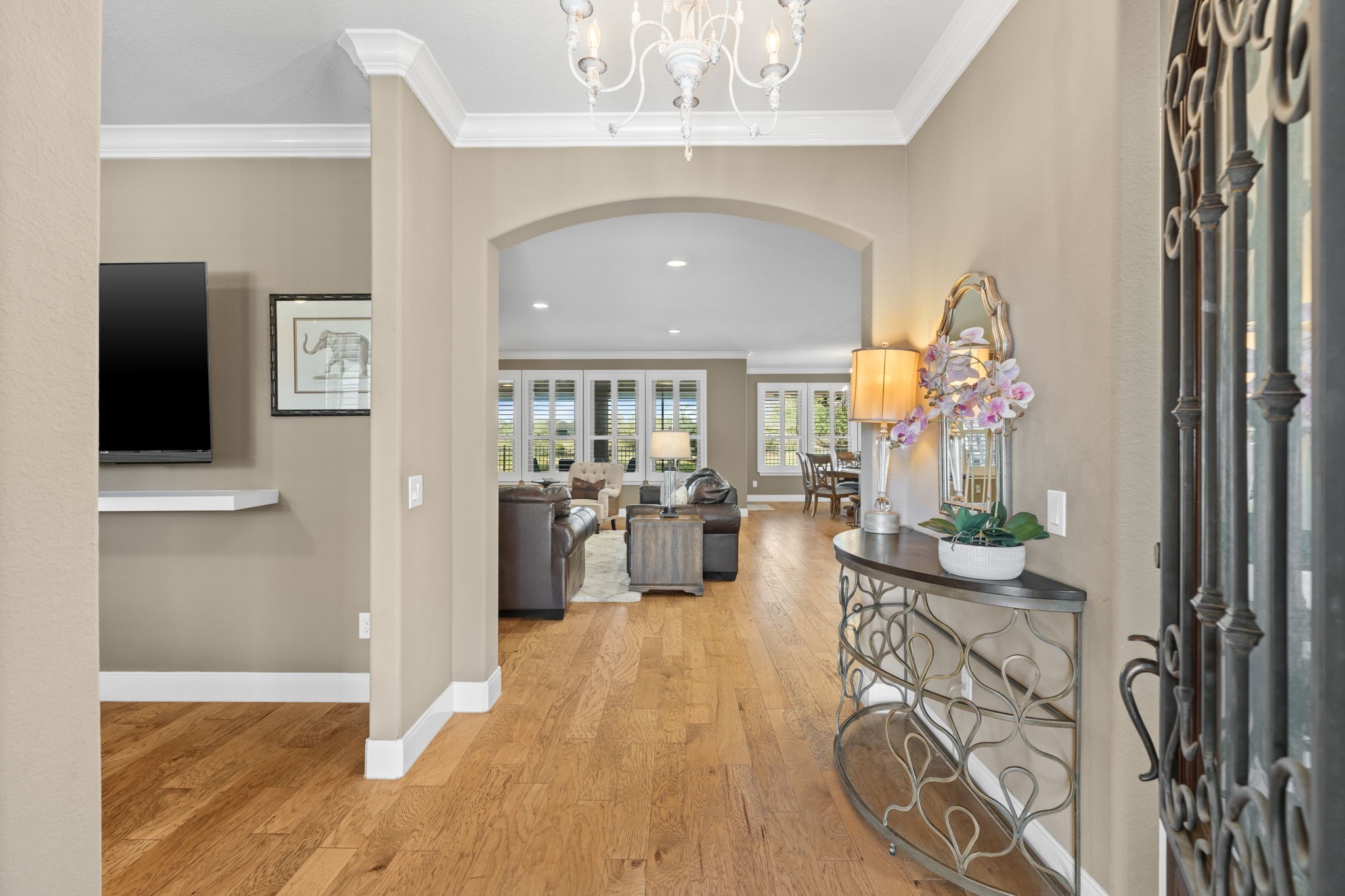 Captivating entryway showcasing elegant crown molding and 5 1/4" baseboards for a refined touch and a distressed white French chandelier. Captivating entryway showcasing elegant crown molding and 5 1/4" baseboards for a refined touch and a distressed white French chandelier.