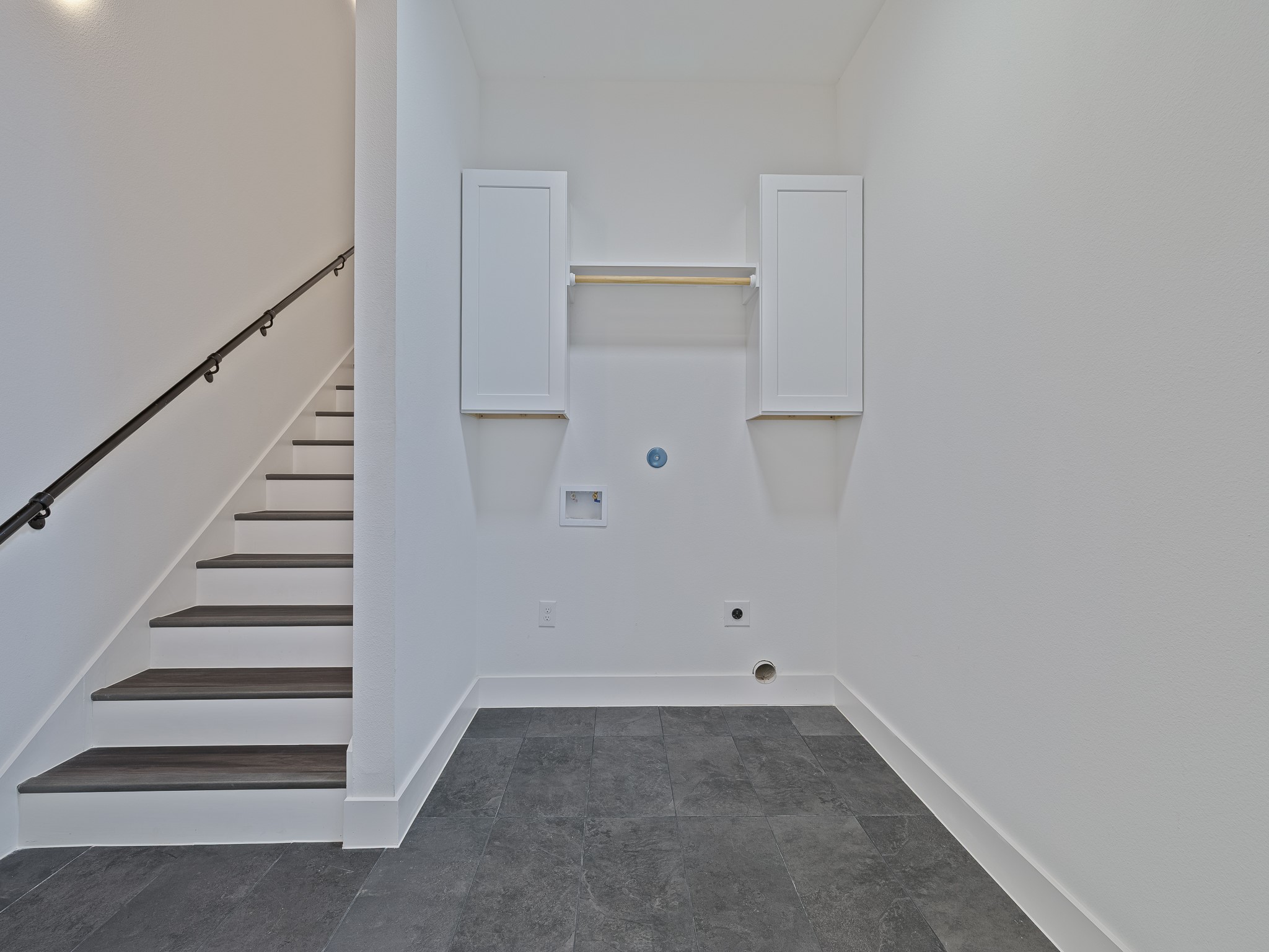 Laundry room with stairs leading up to game room