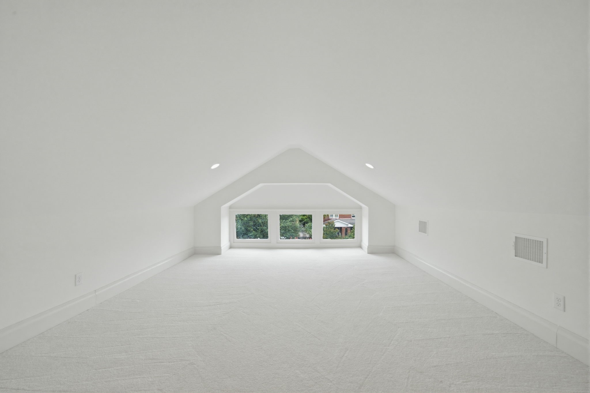 This third story inclosed attic space boast a vaulted ceiling, featuring large windows that offer a serene view of the greenery outside. Perfect for an office, reading nook, or play room.