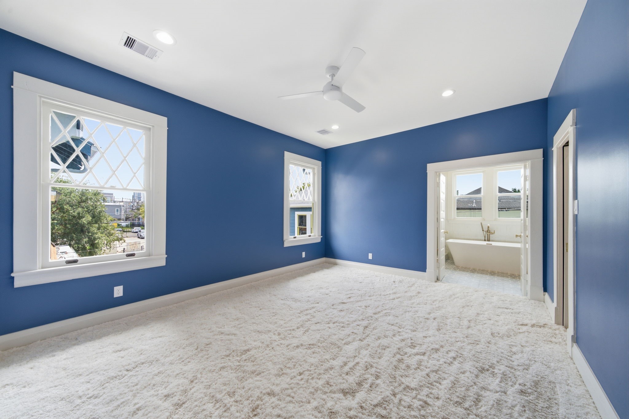 Primary retreat with original windows framing a space for the bed. Large bathroom and closet attached.