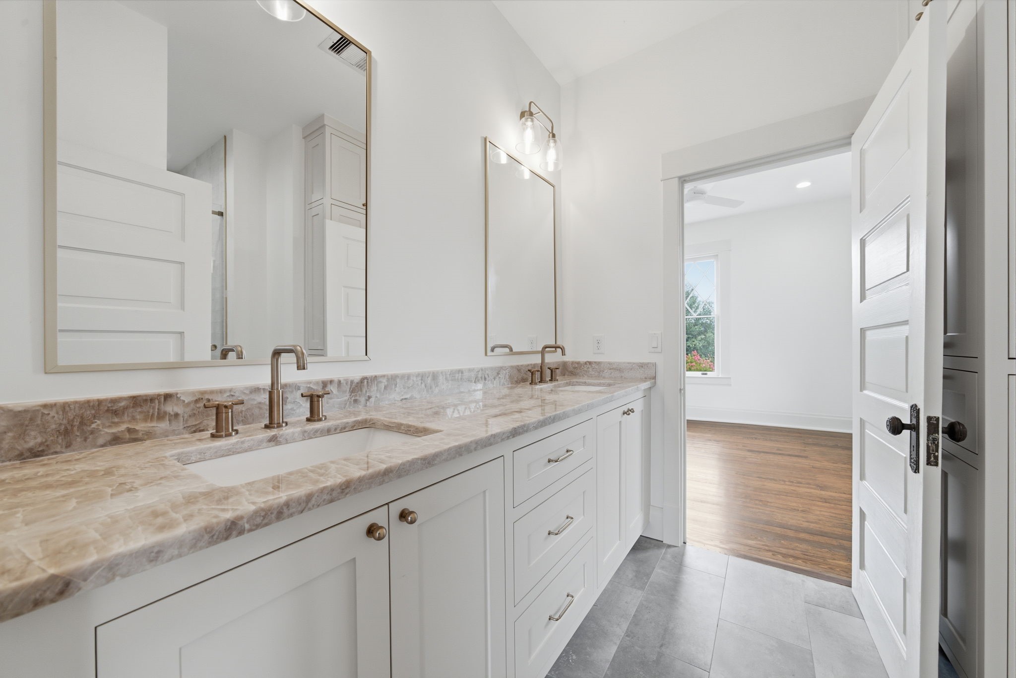 Jack and Jill bath between two of the upstairs bed rooms. One of three bathrooms upstairs. This bathroom featuring a dual-sink vanity with a quartz countertop and Delta fixtures.