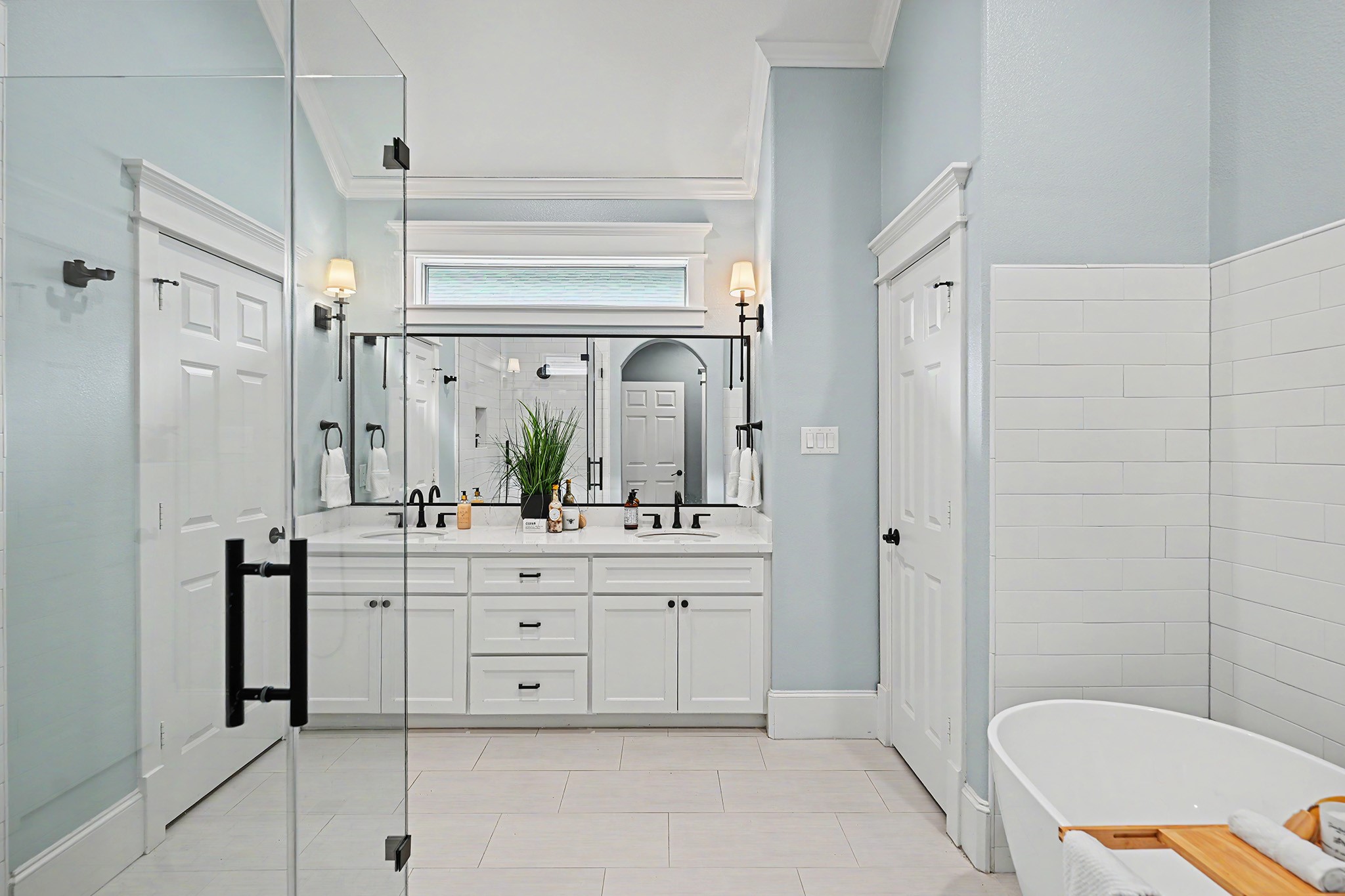 Elegant primary bathroom is well-appointed with quartz counter, double sinks, frameless walk-in shower and freestanding tub.
