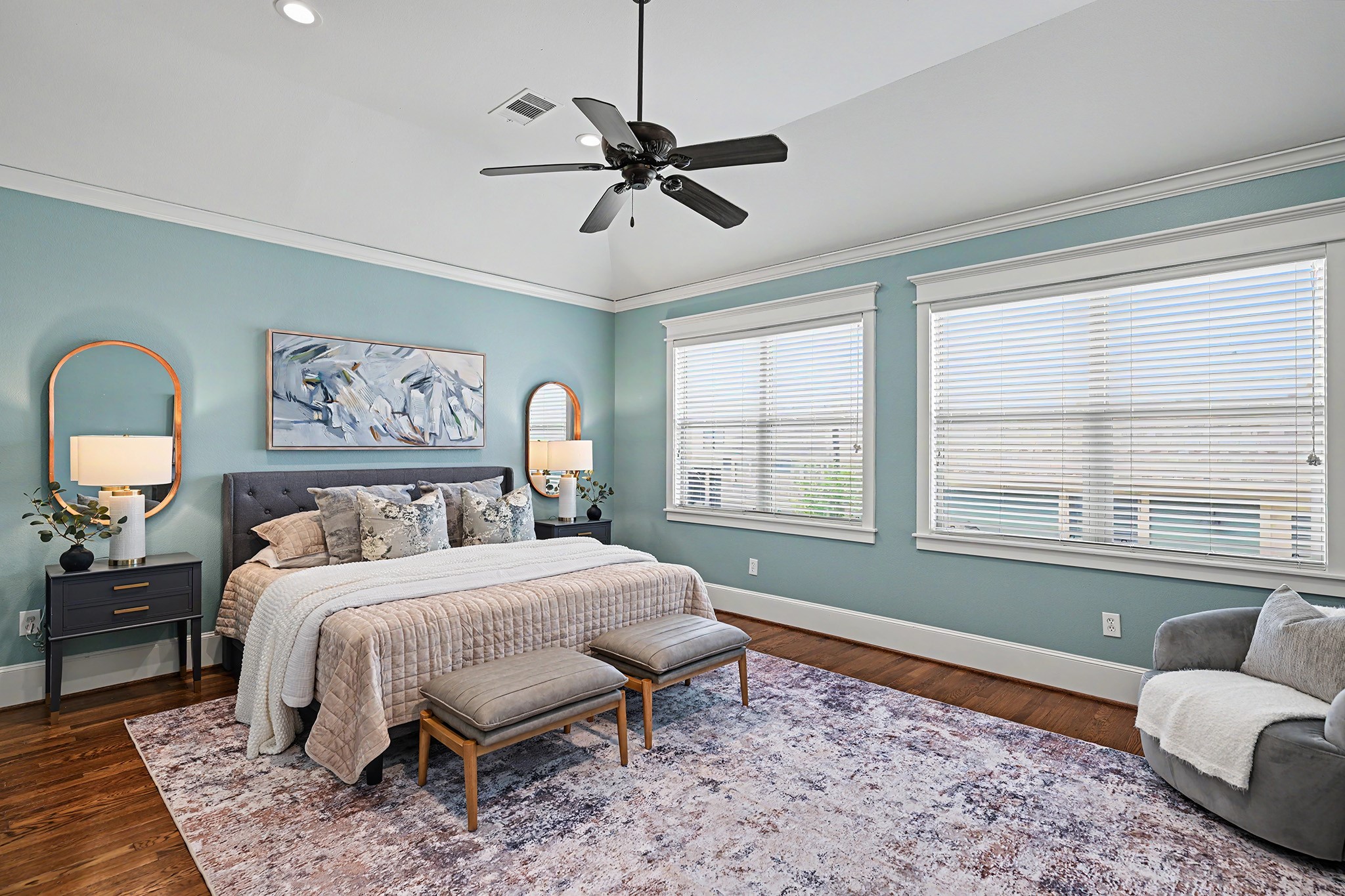 Primary bedroom suite with coffered ceiling, window treatments and sitting area.