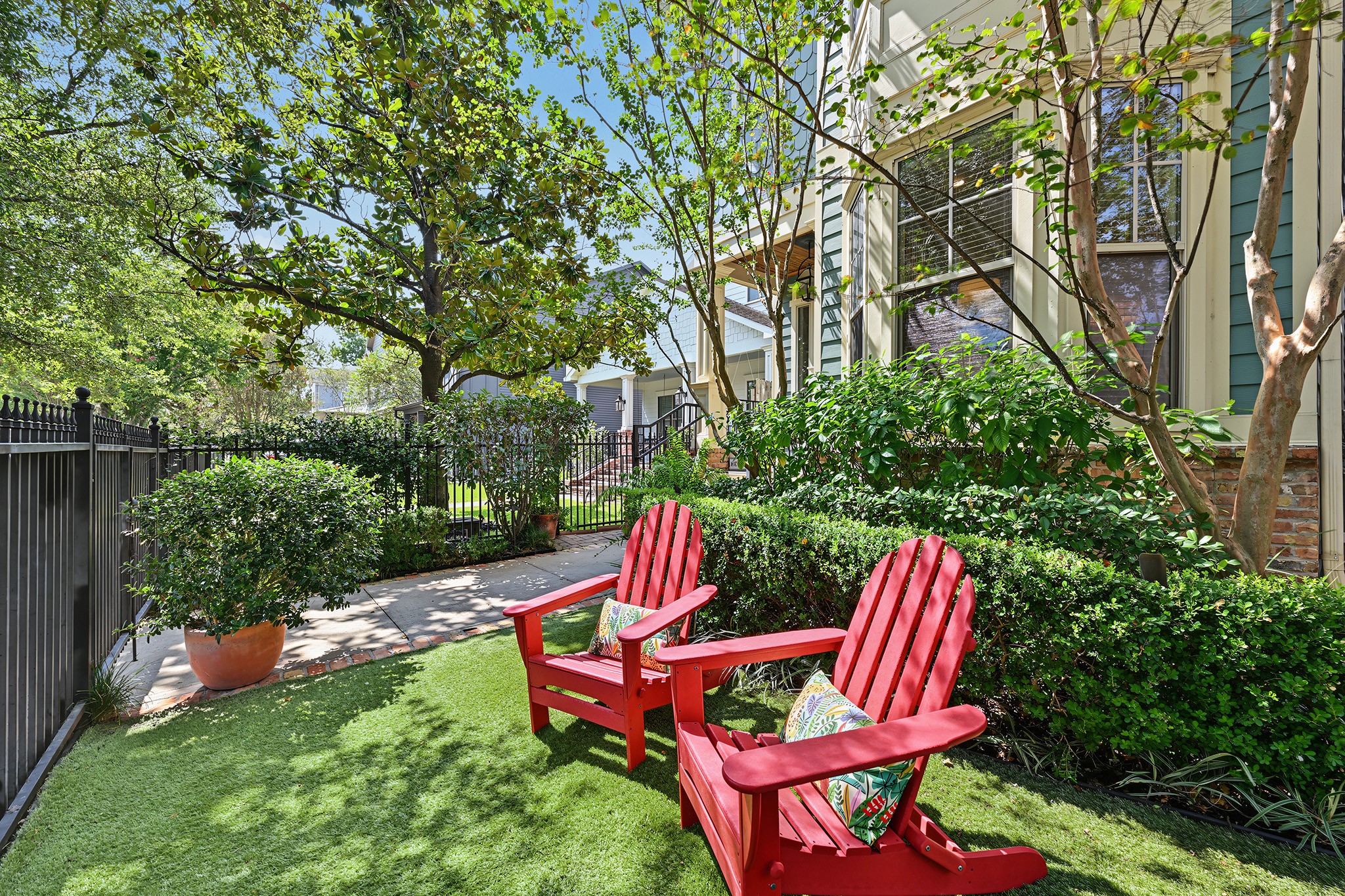 Fully fenced front yard features turfed greenspace, lush landscaping, lighting and shade trees. Sprinkler system in place.
