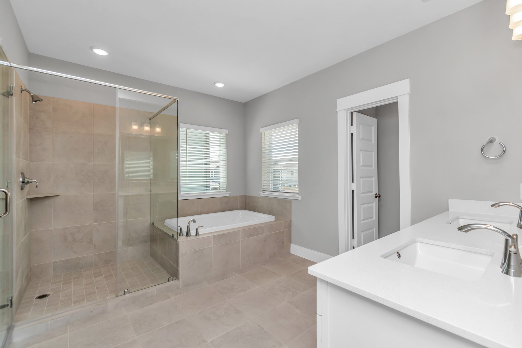 Spa-Like Bath with Spacious Walk-In Shower, Soaking Tub, & Double Sinks with Luxurious Quartz Countertops.