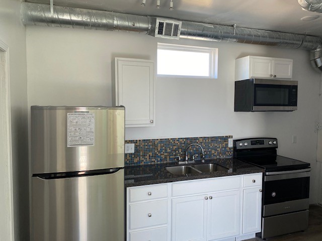 Kitchen in duplex unit 1 with granite countertops and SS appliances.