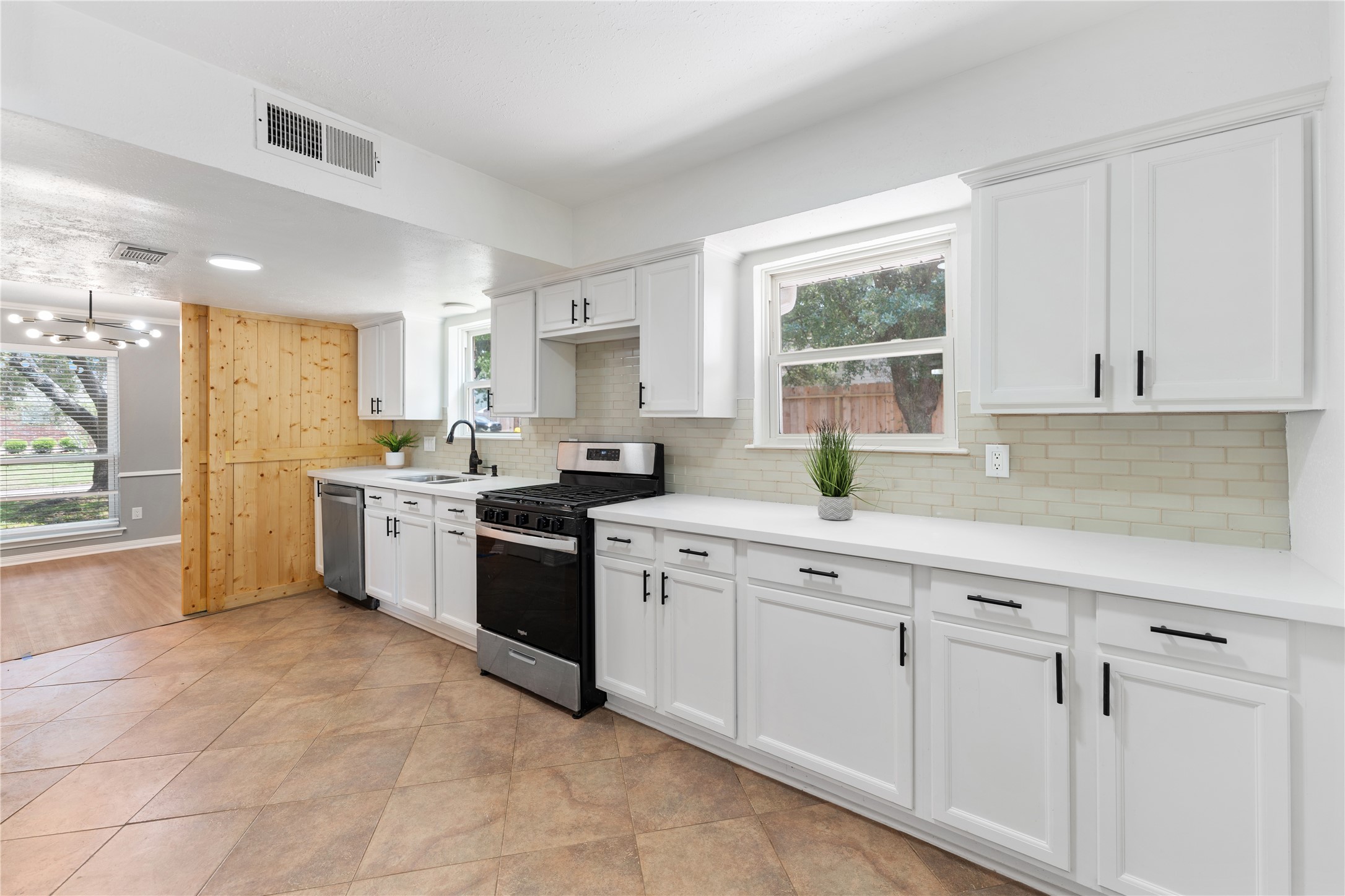 Alternate view of the kitchen, featuring new quartz countertops, a glass finished backsplash, and stainless-steel appliances.
