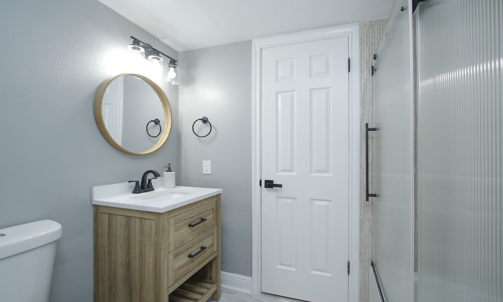 Alternate view of the bathroom, featuring a completely renovated shower / tub combo with frosted glass enclosure