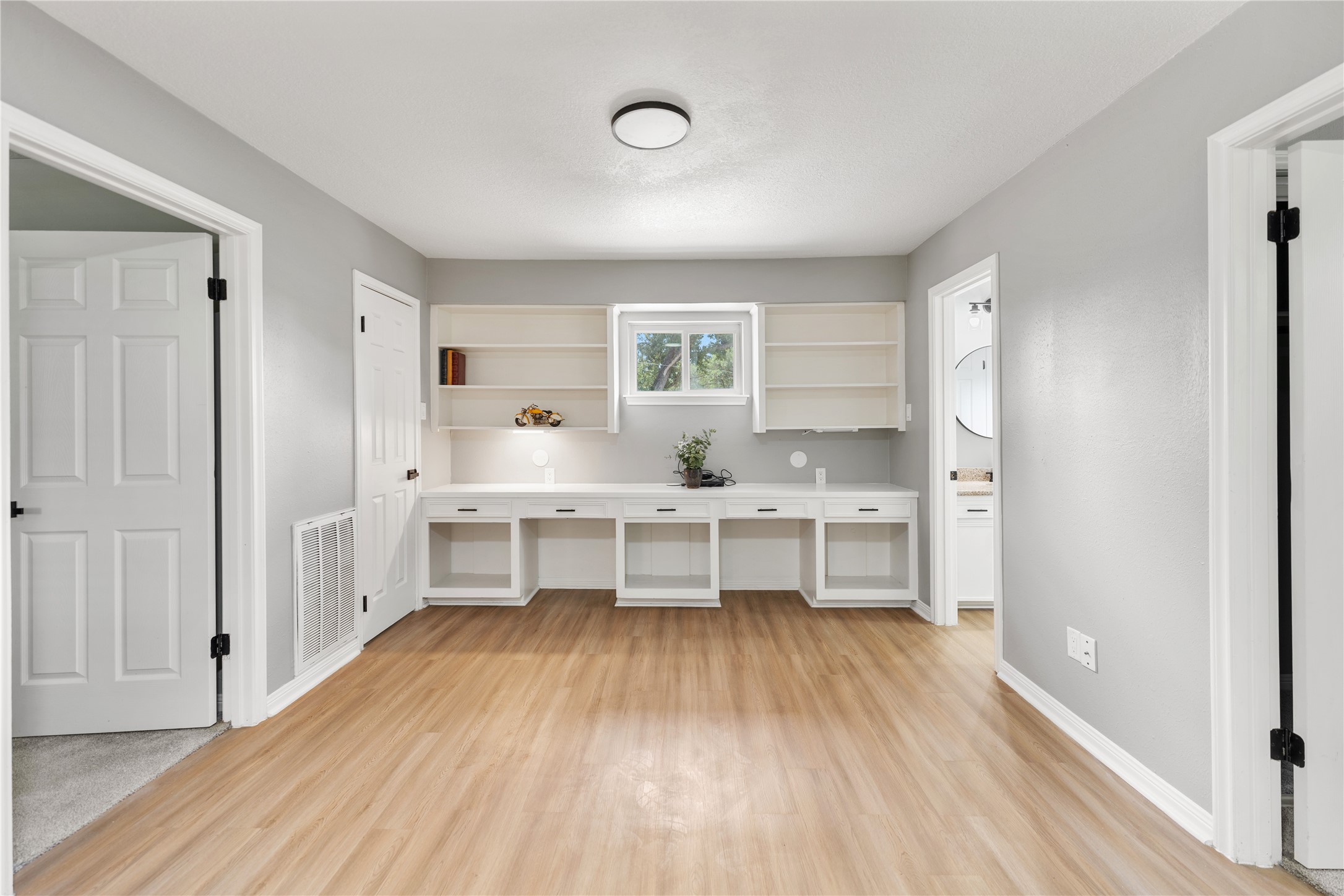Another view of the second-floor flex area includes built-in shelves and a desk area under a window, providing functionality and natural light