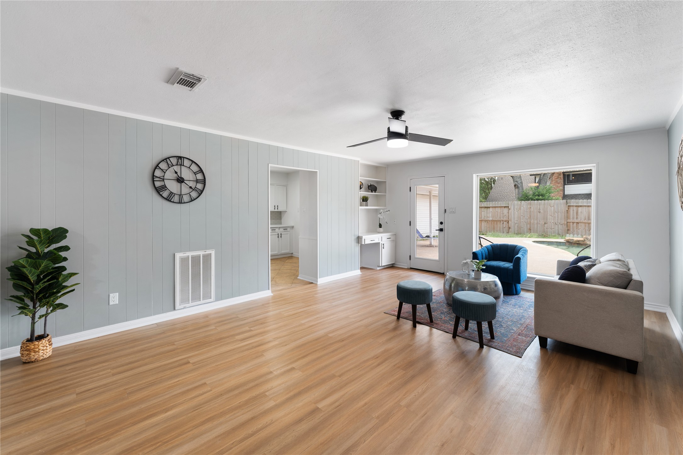Another view of the bright and spacious living room, featuring a built in bookcase and desk.