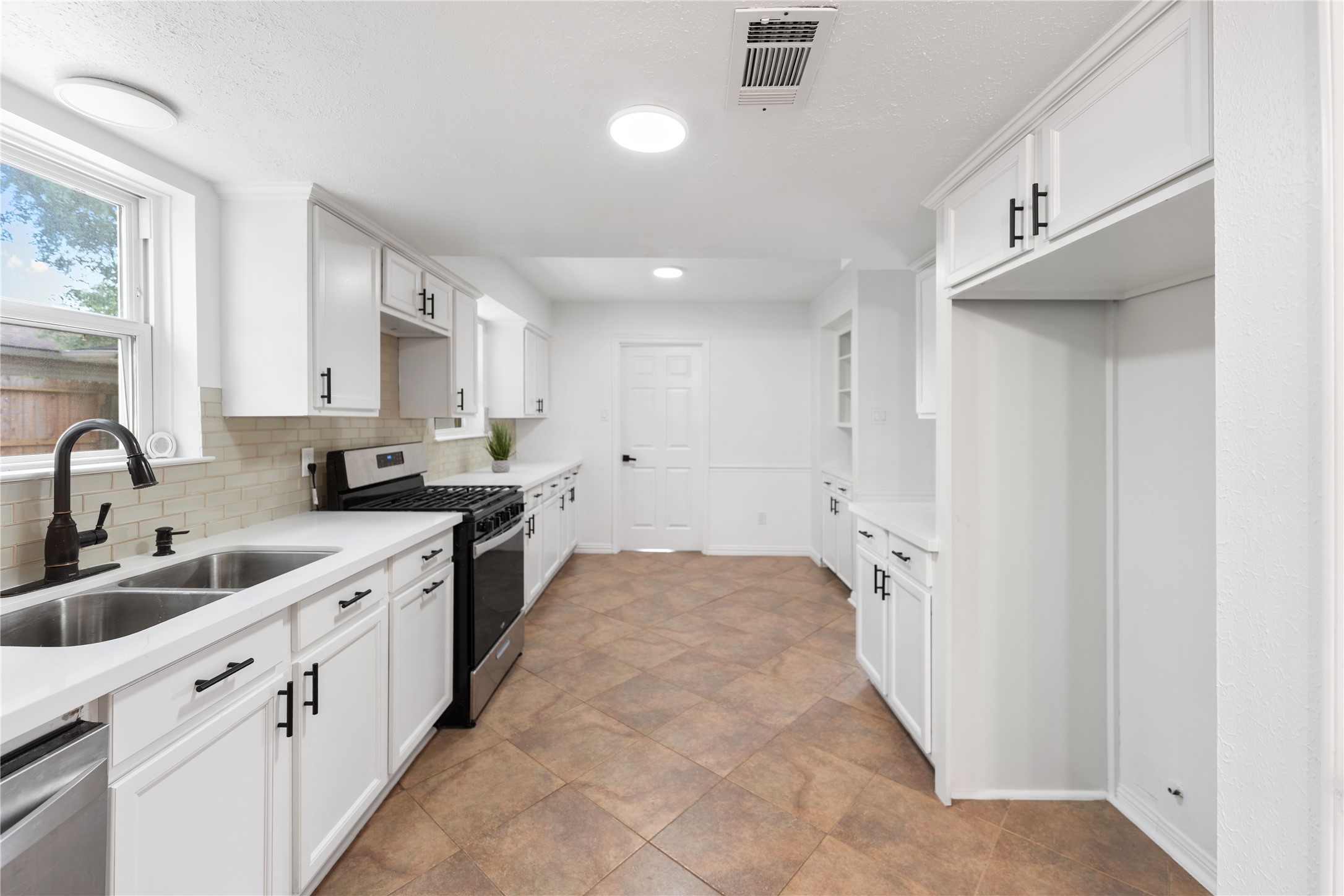 Another view of the kitchen, showcasing the ample storage space.