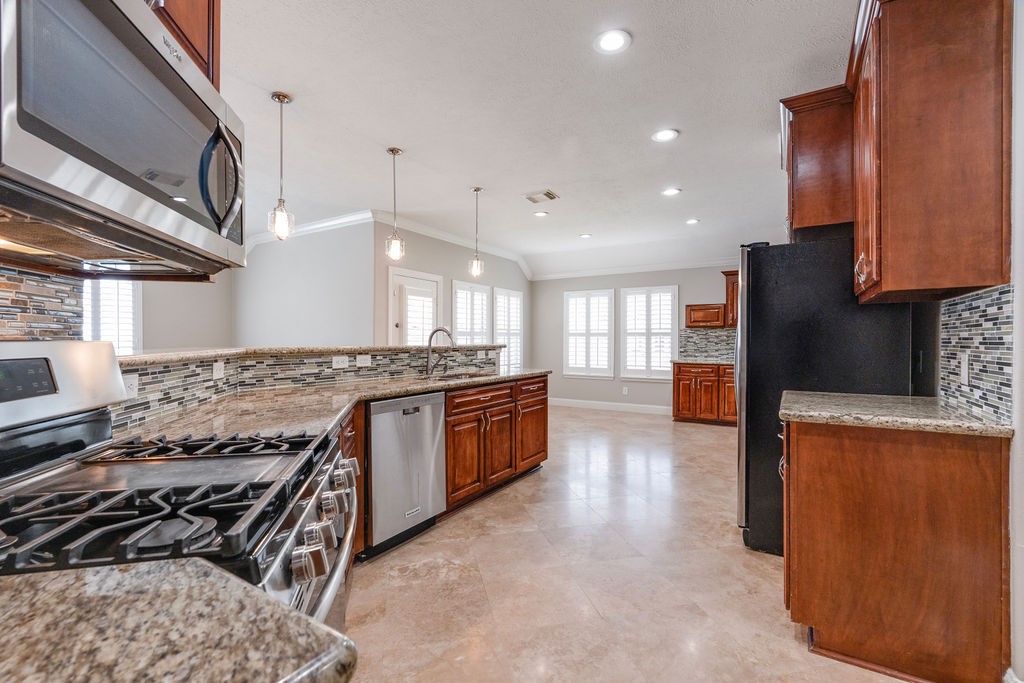 Kitchen with many cabinets. Travertine floors.