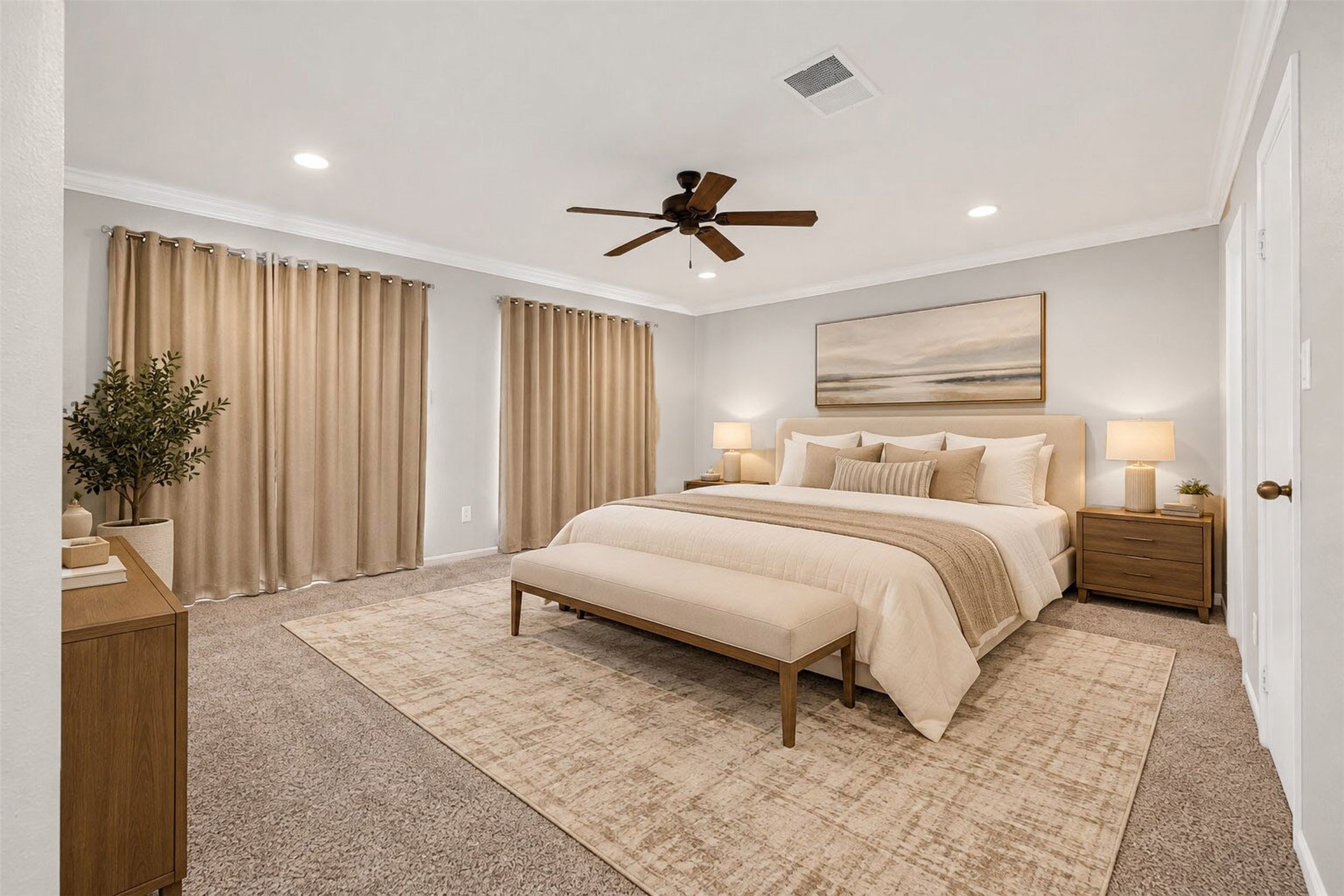 Virtually staged as a serene retreat, the primary bedroom fits a king bed with bench, matching nightstands, and a dresser with ease. Carpet underfoot, a ceiling fan above, and curtains drawn across two walls.