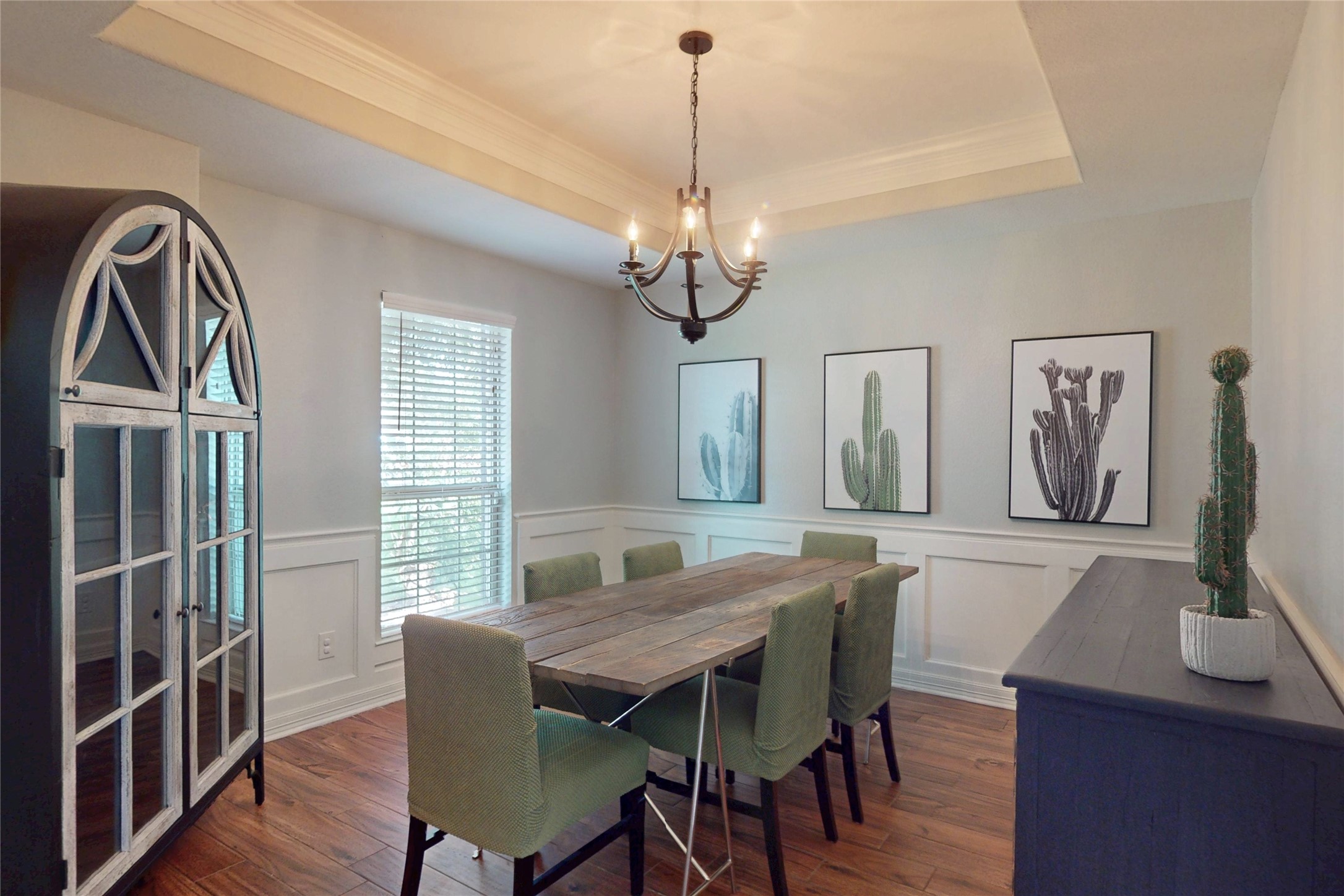 Formal dining with tray ceiling, chandelier and wainscoting