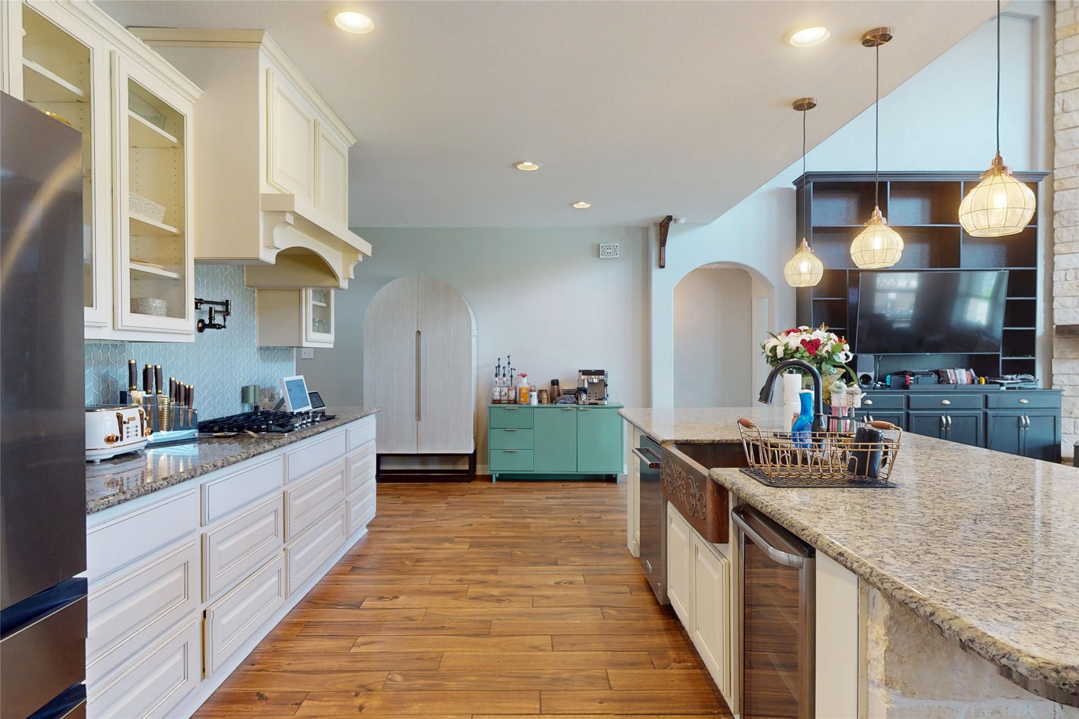 Kitchen with granite counters, pendant lighting and beverage cooler