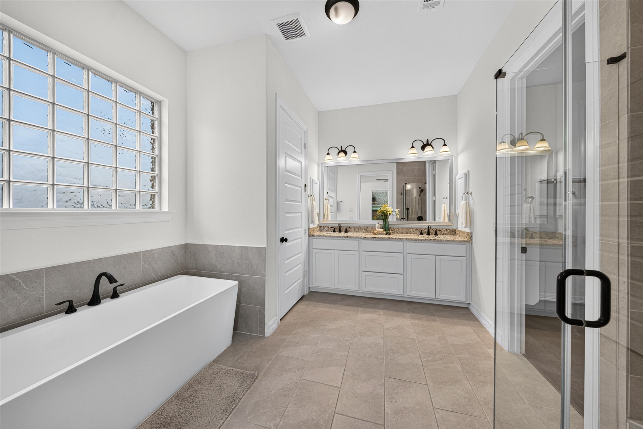 Indulge in pure relaxation in the deep soaking tub, serving as a serene focal point in the primary en suite.