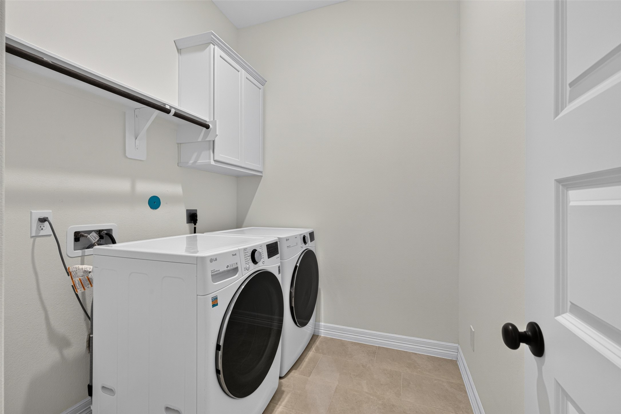 This practical and dedicated laundry room offers convenient built-in storage and upper shelving, making daily chores organized and effortless.