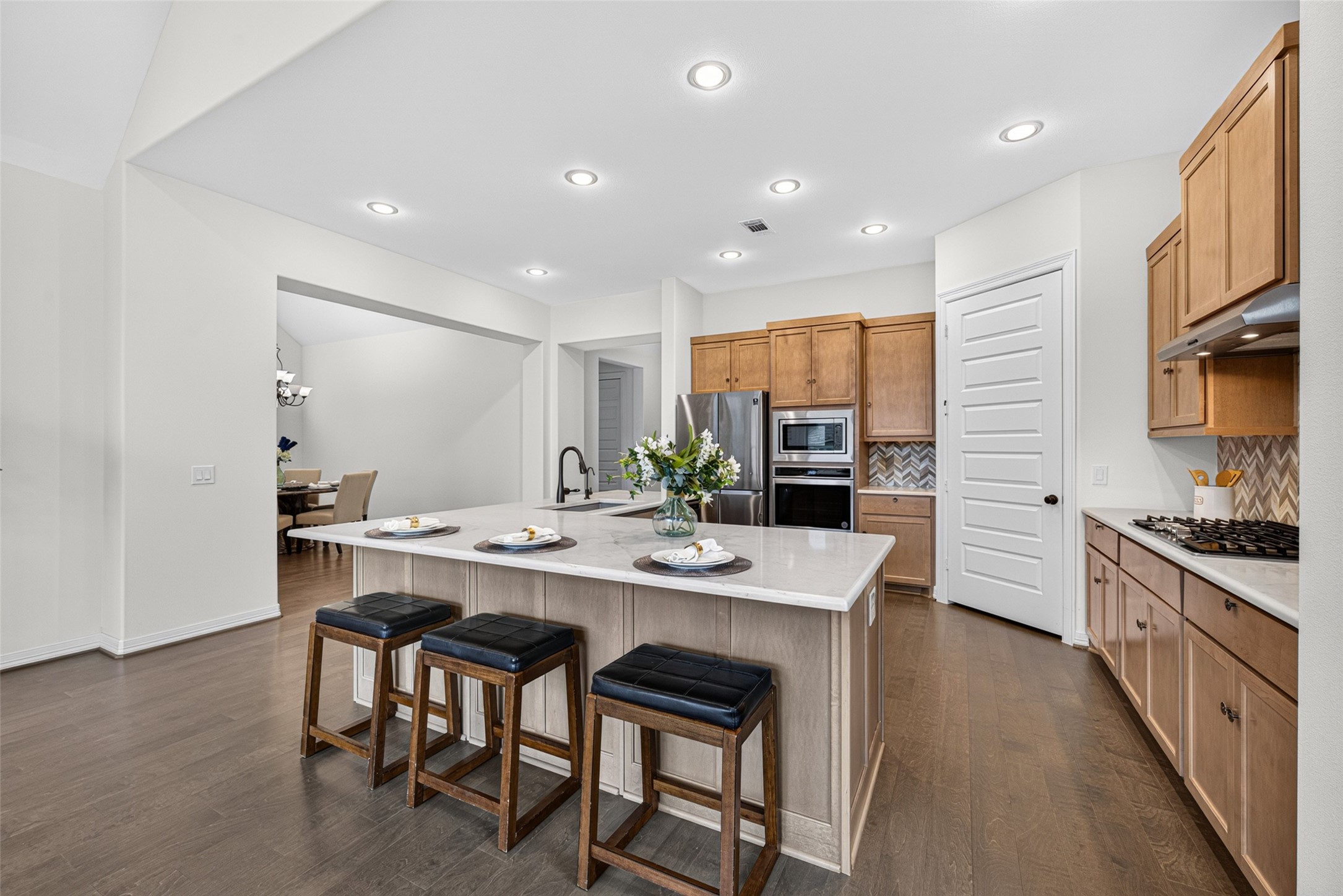 The stunning L-shaped quartz island serves as the ultimate anchor for both morning coffee routines and casual evening gatherings.