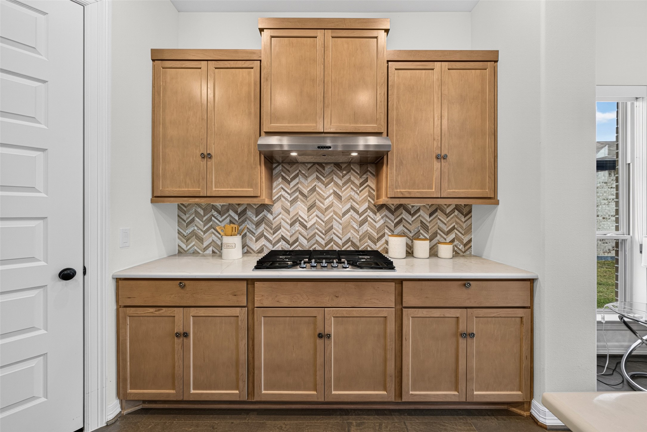 Exquisite custom cabinetry brings rich texture and practical storage solutions, keeping all your culinary essentials neatly organized.