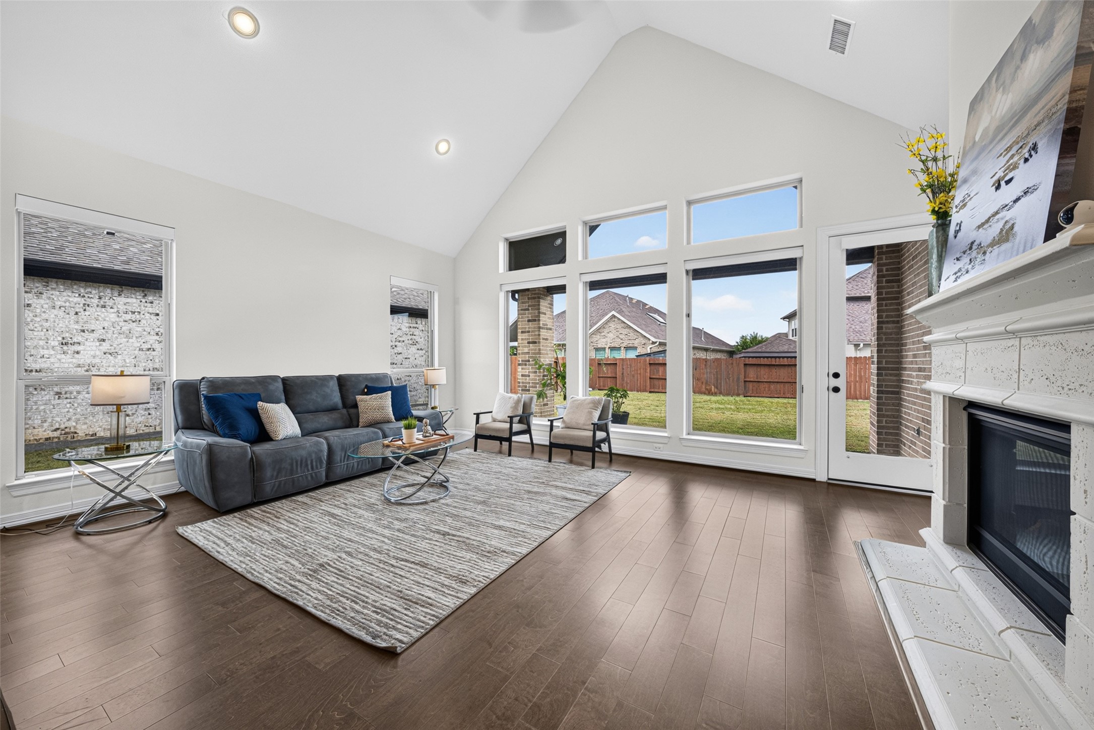 Centered around a cozy fireplace, this welcoming space offers picturesque views of the tranquil backyard, making it the ultimate spot to unwind after a long day.