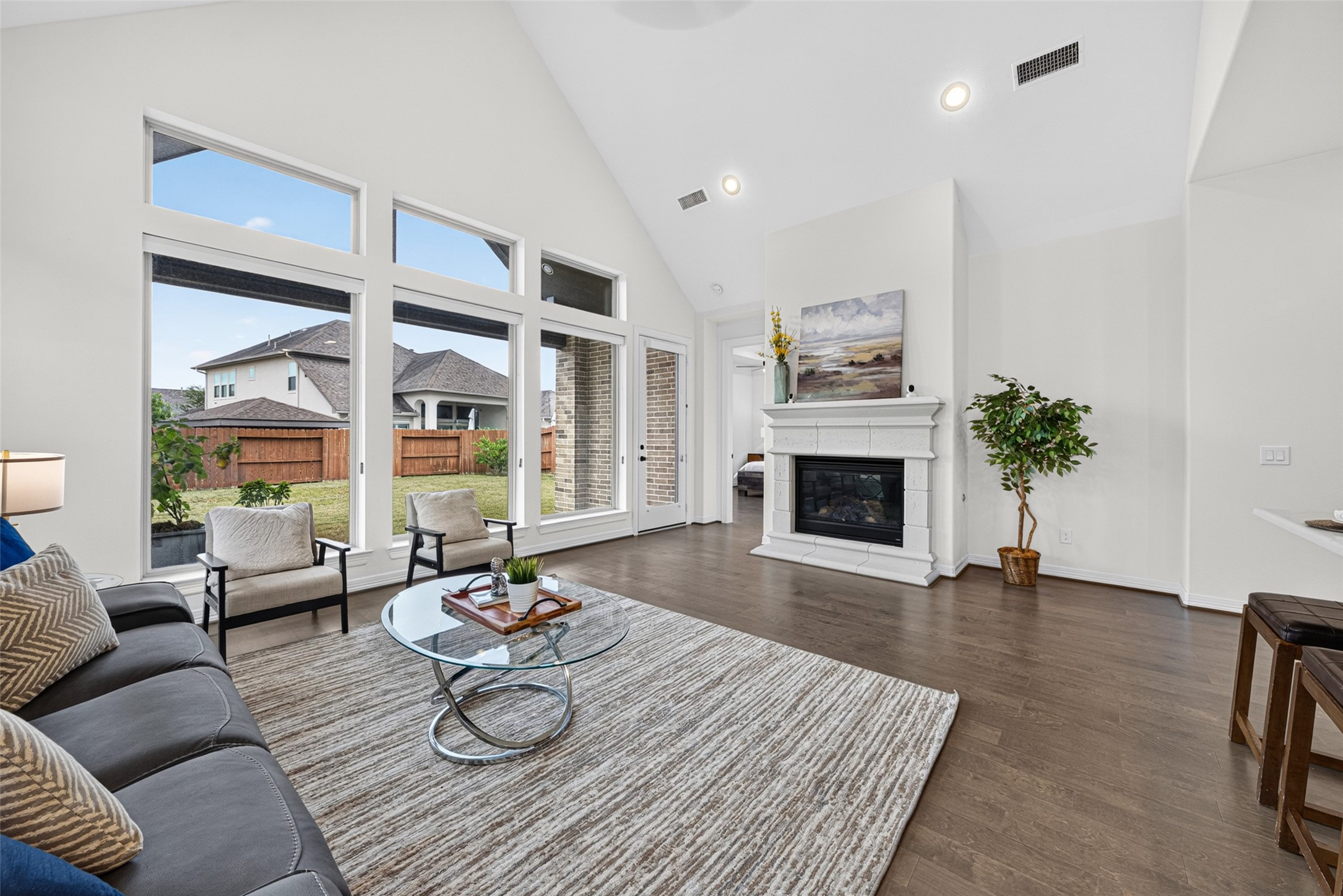 The heart of the home opens up into a luminous living room framed by wide, expansive windows that draw in an abundance of natural light.