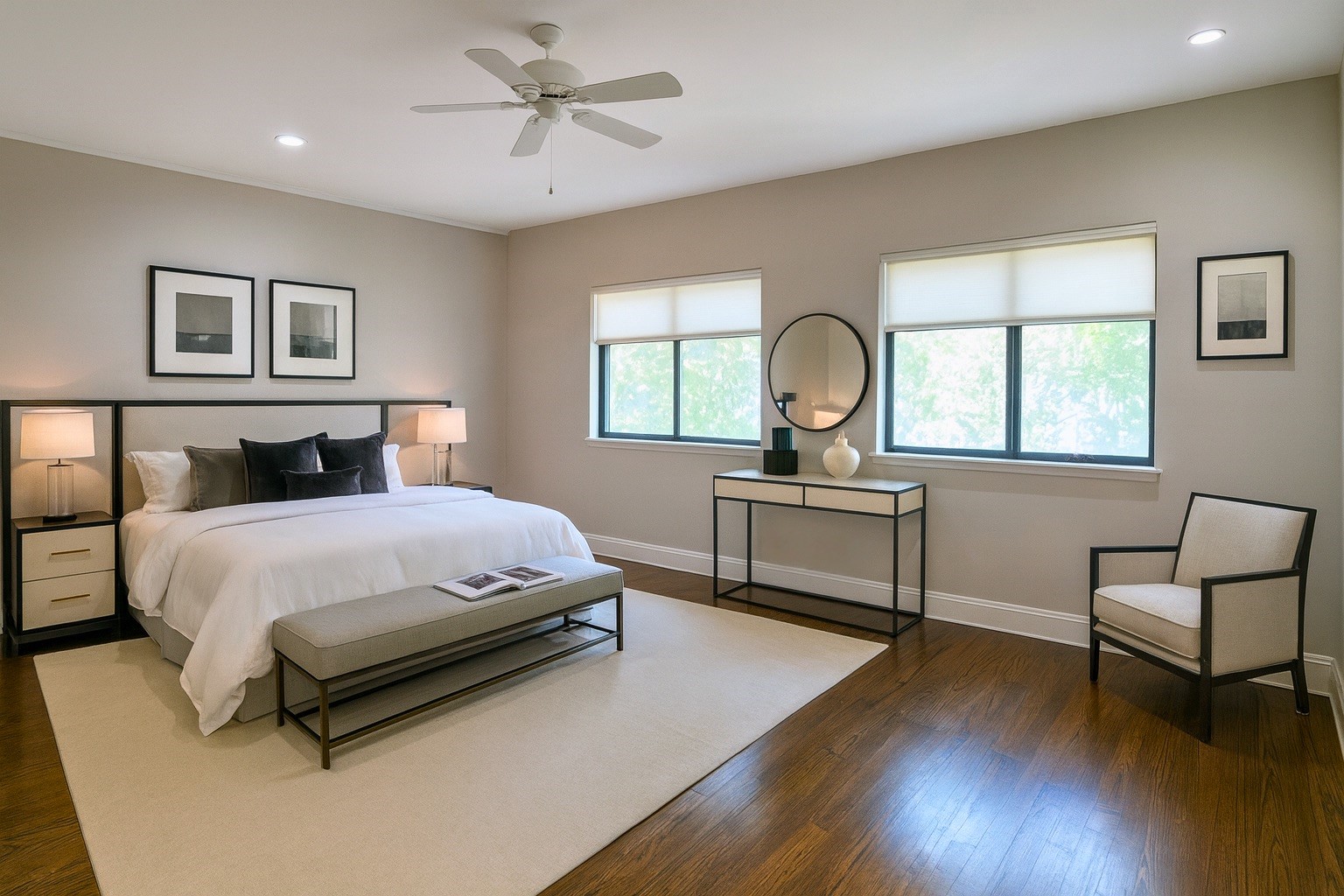 The primary suite (digitally staged) is a spacious retreat, comfortably fitting a king bed with room to spare for a seating area, while large windows frame serene outdoor views.