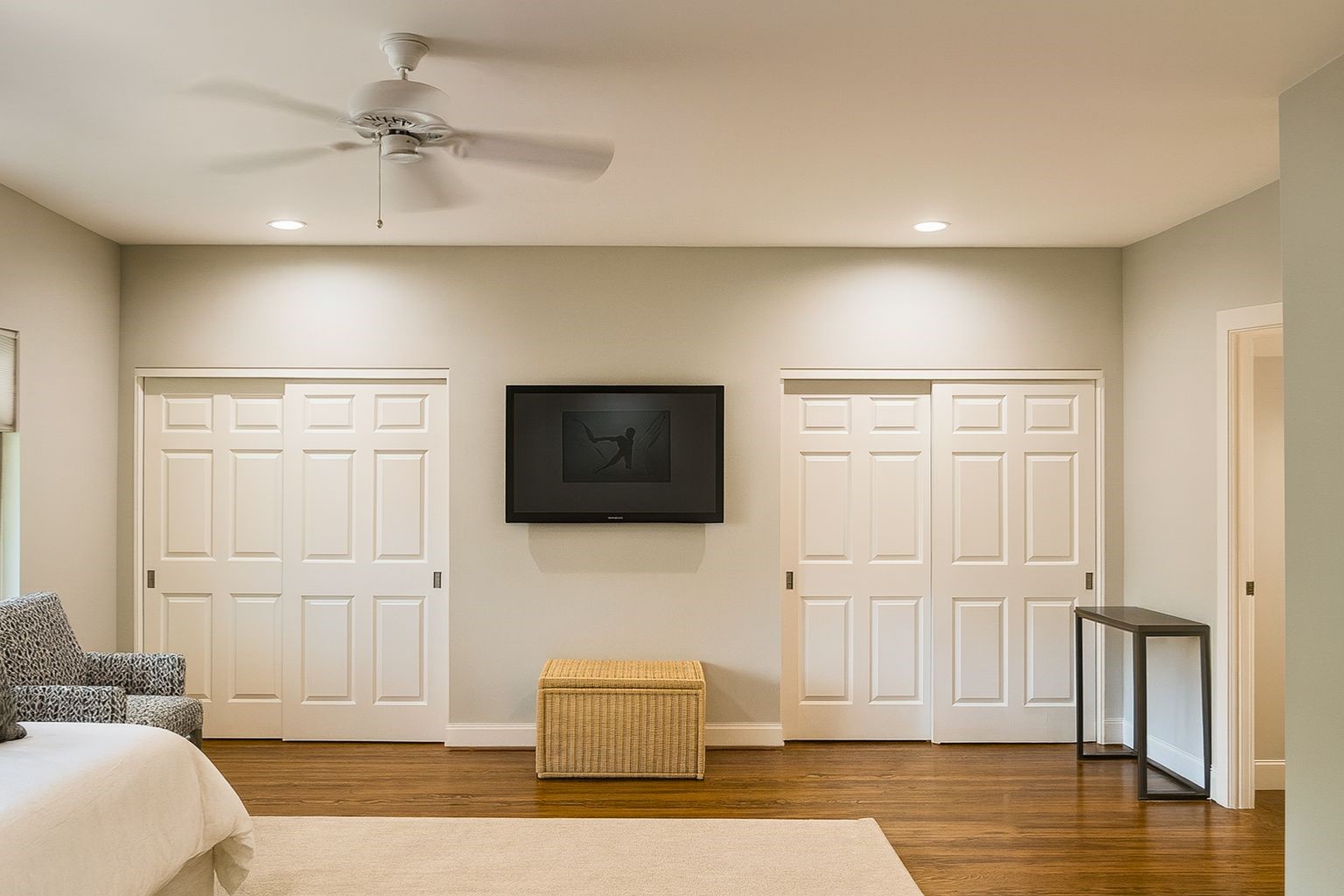 The primary suite (digitally staged) is a spacious retreat, comfortably fitting a king bed with room to spare for a seating area, while large windows frame serene outdoor views.