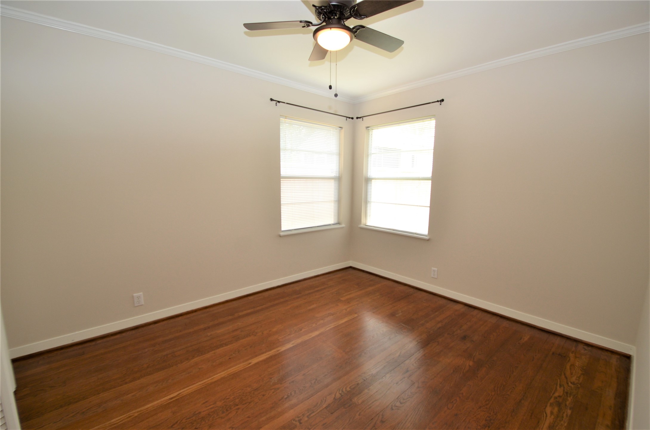 Secondary bedroom offers beautiful woodfloors, ceiling fan and view of backyard.