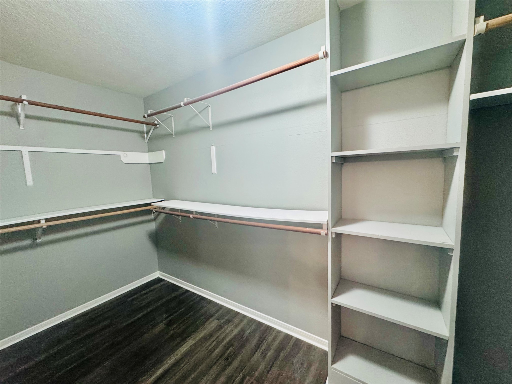 Spacious walk-in closet featuring ample shelving and hanging space, perfect for organizing your wardrobe with ease.
