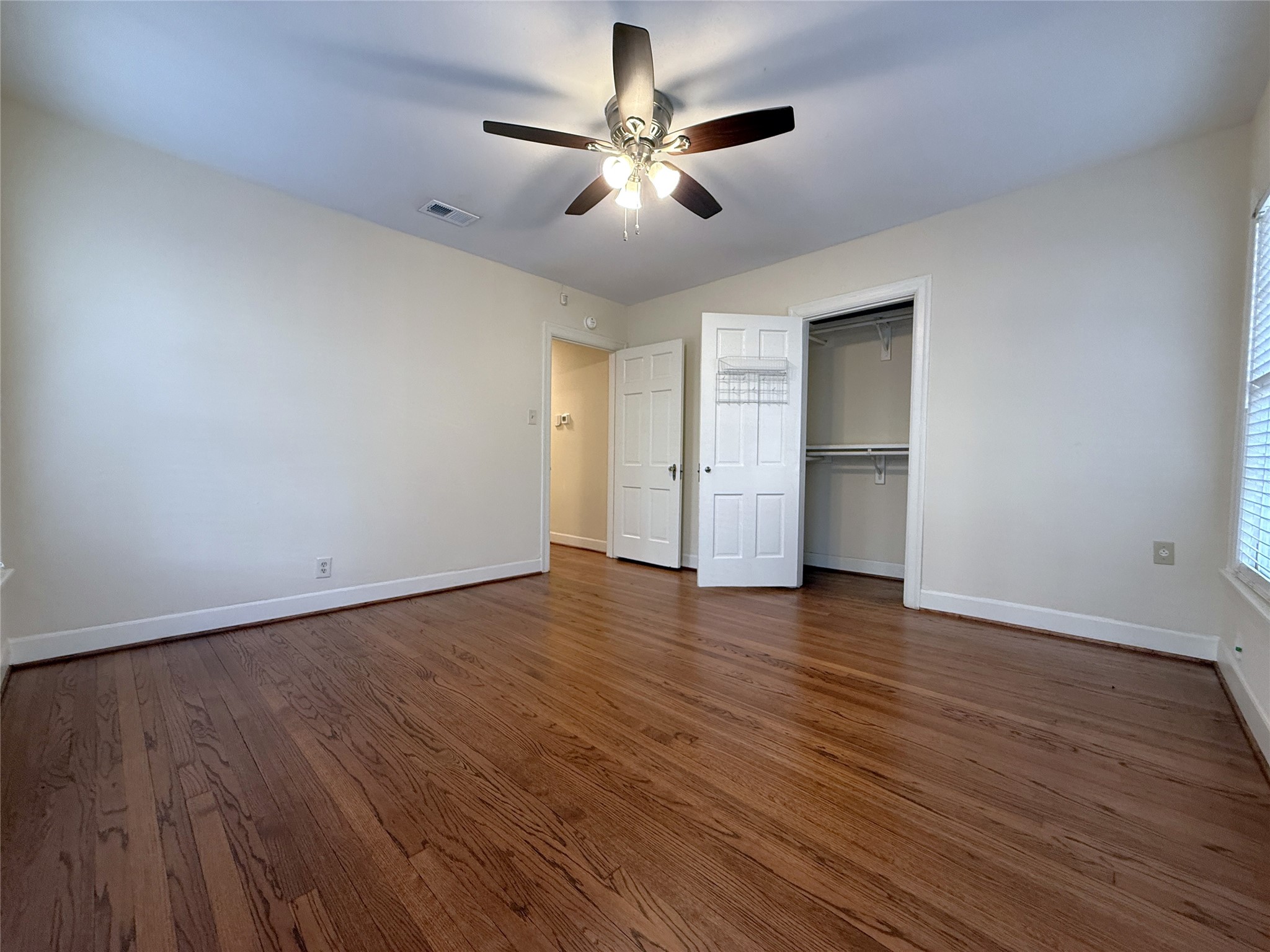 Alternate view of the back bedroom. The closet offers double hang bars.