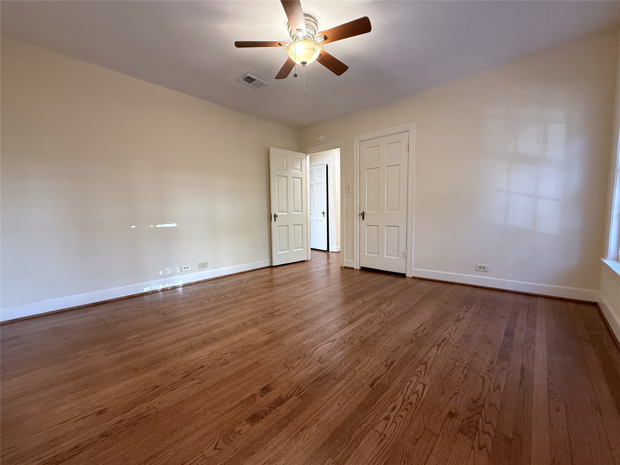 Alternate view of the primary bedroom. Behind the closed door on the opposite side of the room is another closet.