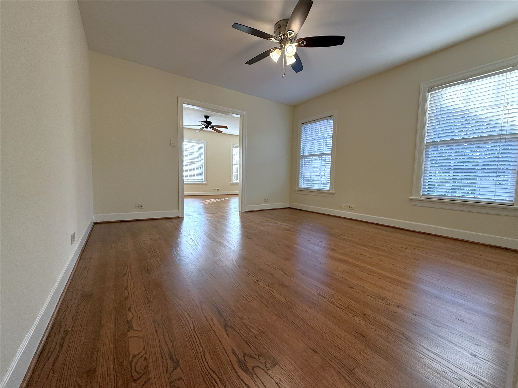 In the dining room, with ceiling fan, natural light flows in from twin windows.