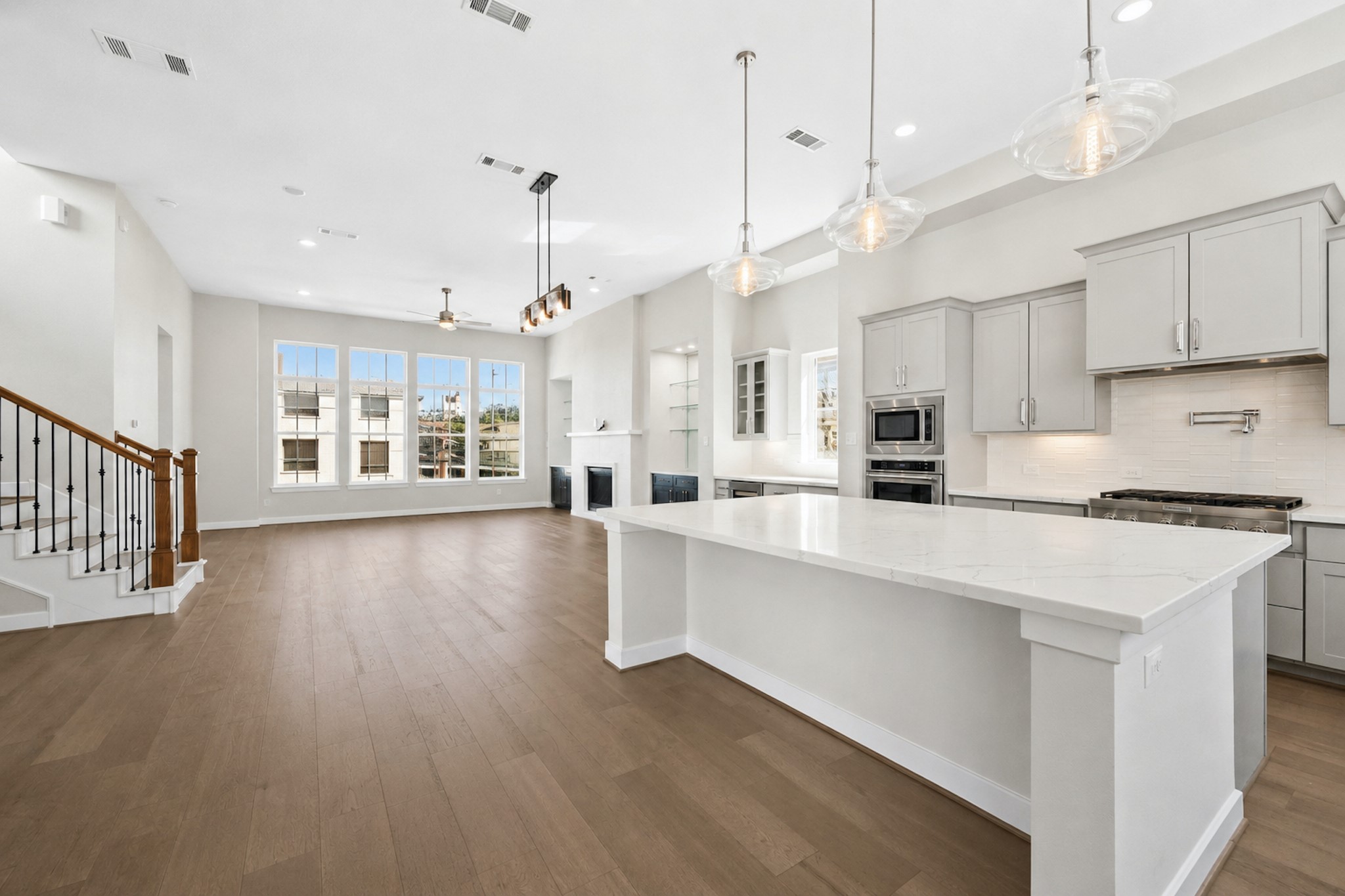 Open-concept kitchen with oversized quartz island, extensive workspace, and direct connection to the living and dining areas.