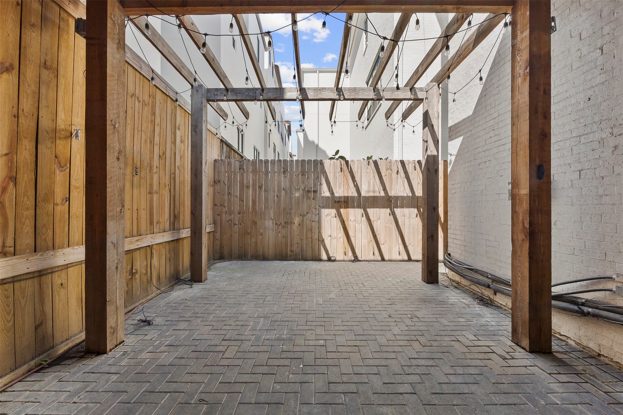 Expansive covered outdoor entertaining area featuring a pergola and flexible gathering space for dining and relaxing.