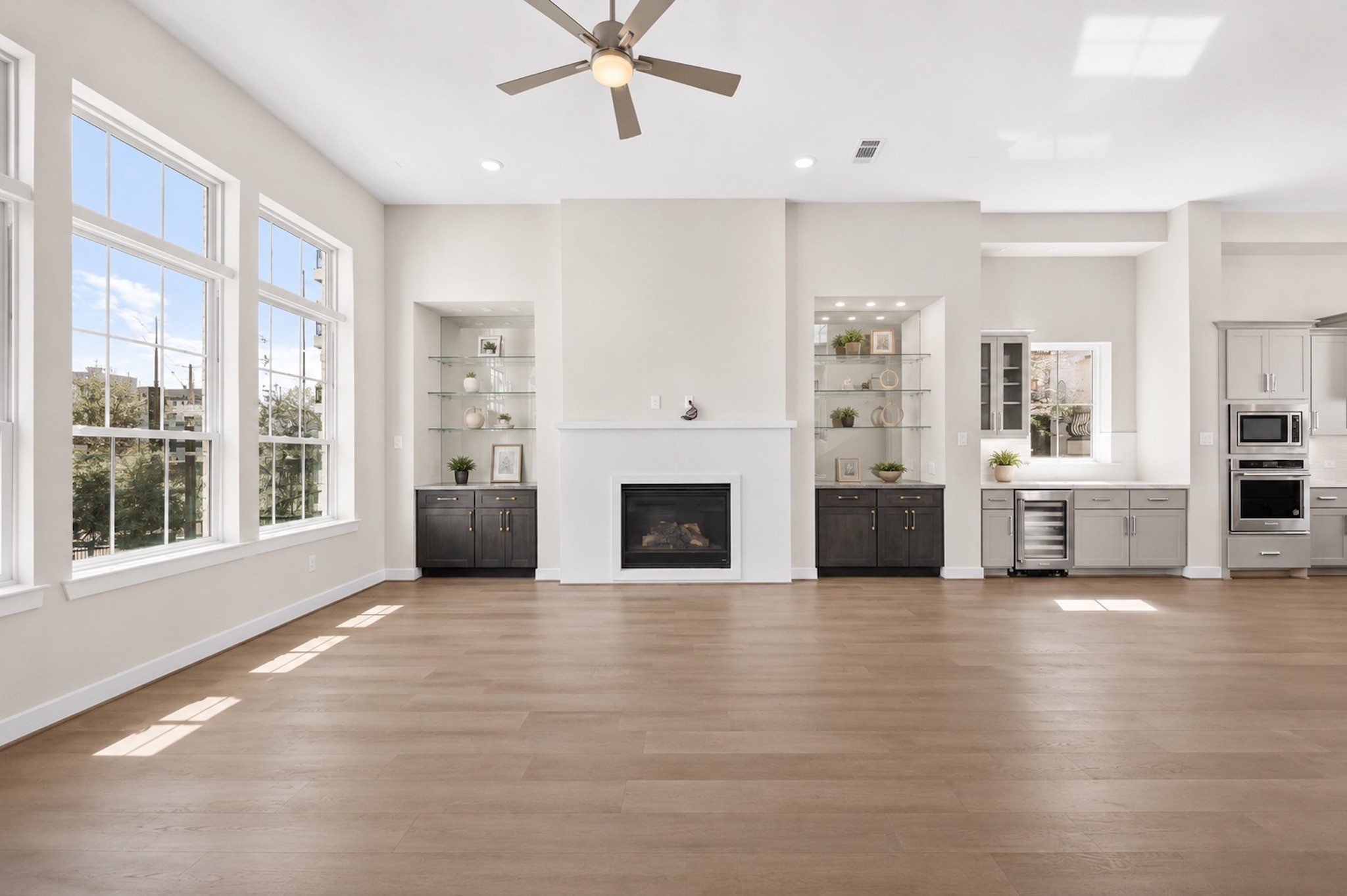 Bright second-floor living area with expansive windows, wood flooring, and abundant natural light from the home's corner position.