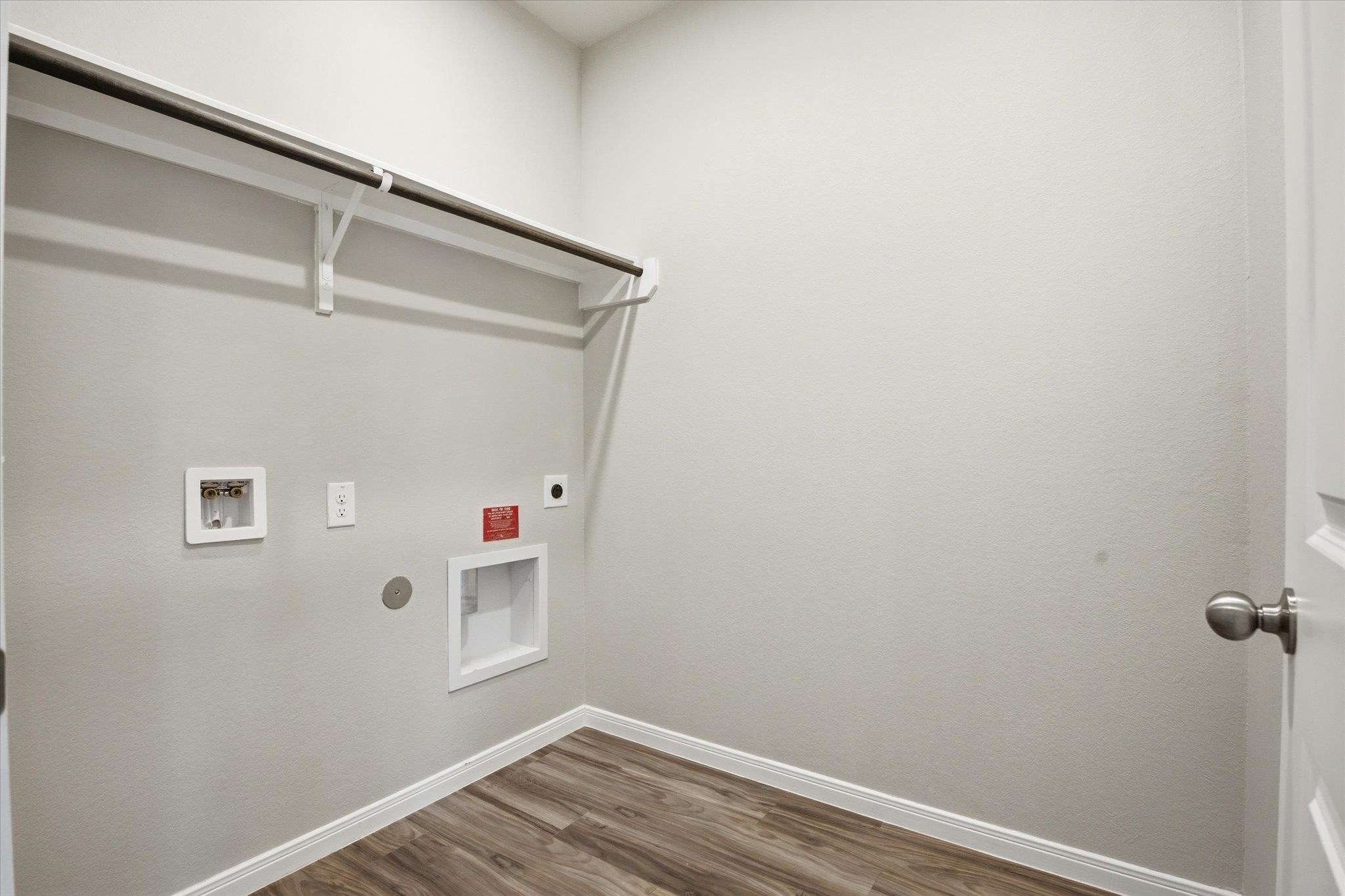 This bright and spacious laundry room offers modern convenience with ample hanging space, making laundry days a breeze.