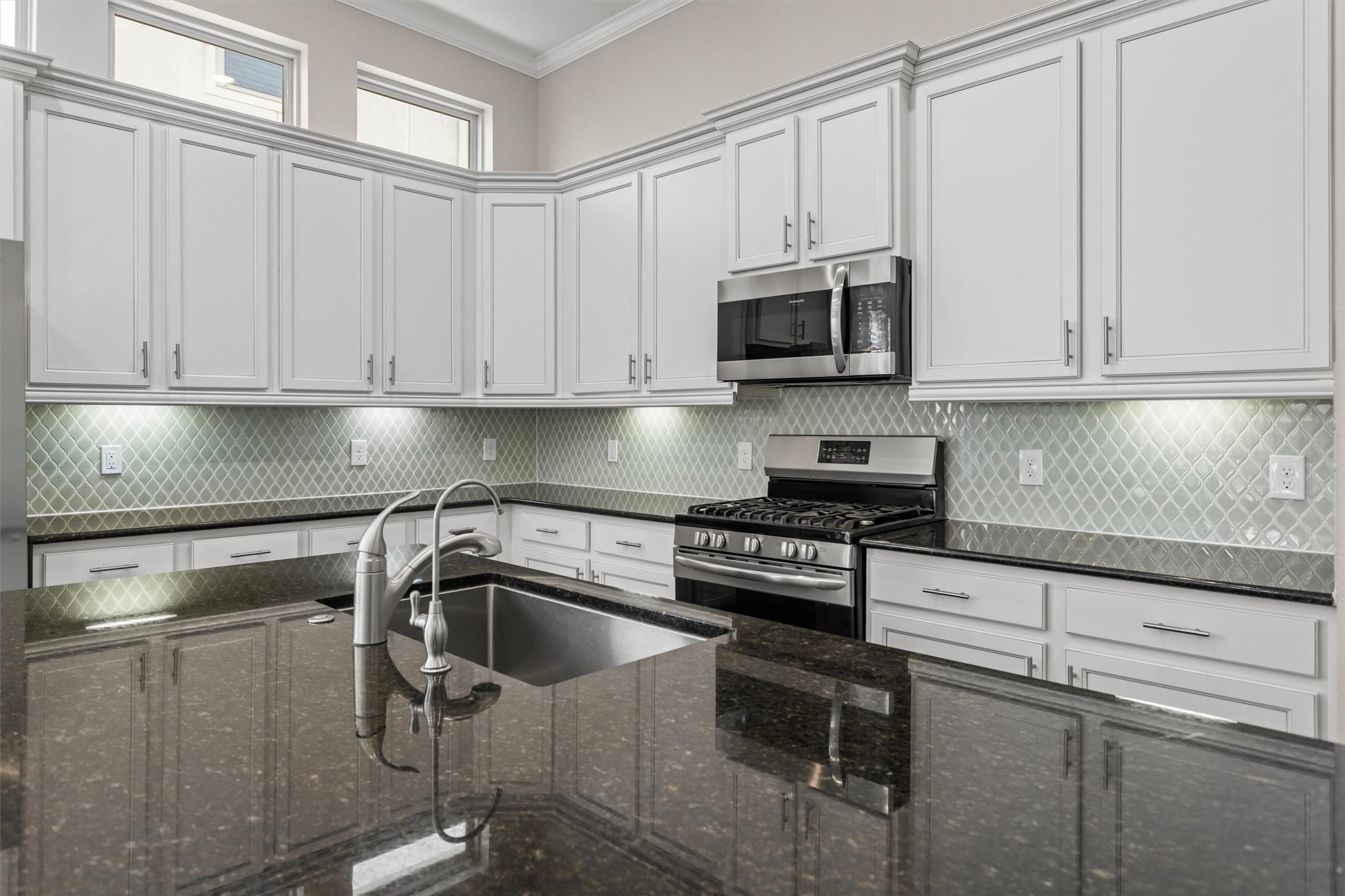 Under cabinet lighting compliments the additional natural light from the picture windows above