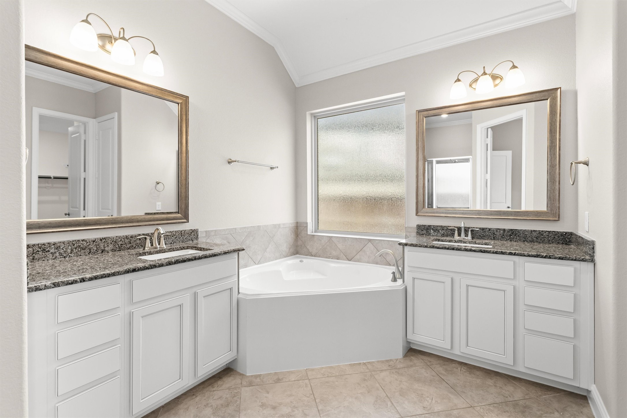 Primary bathroom with double vanities and corner soaking tub