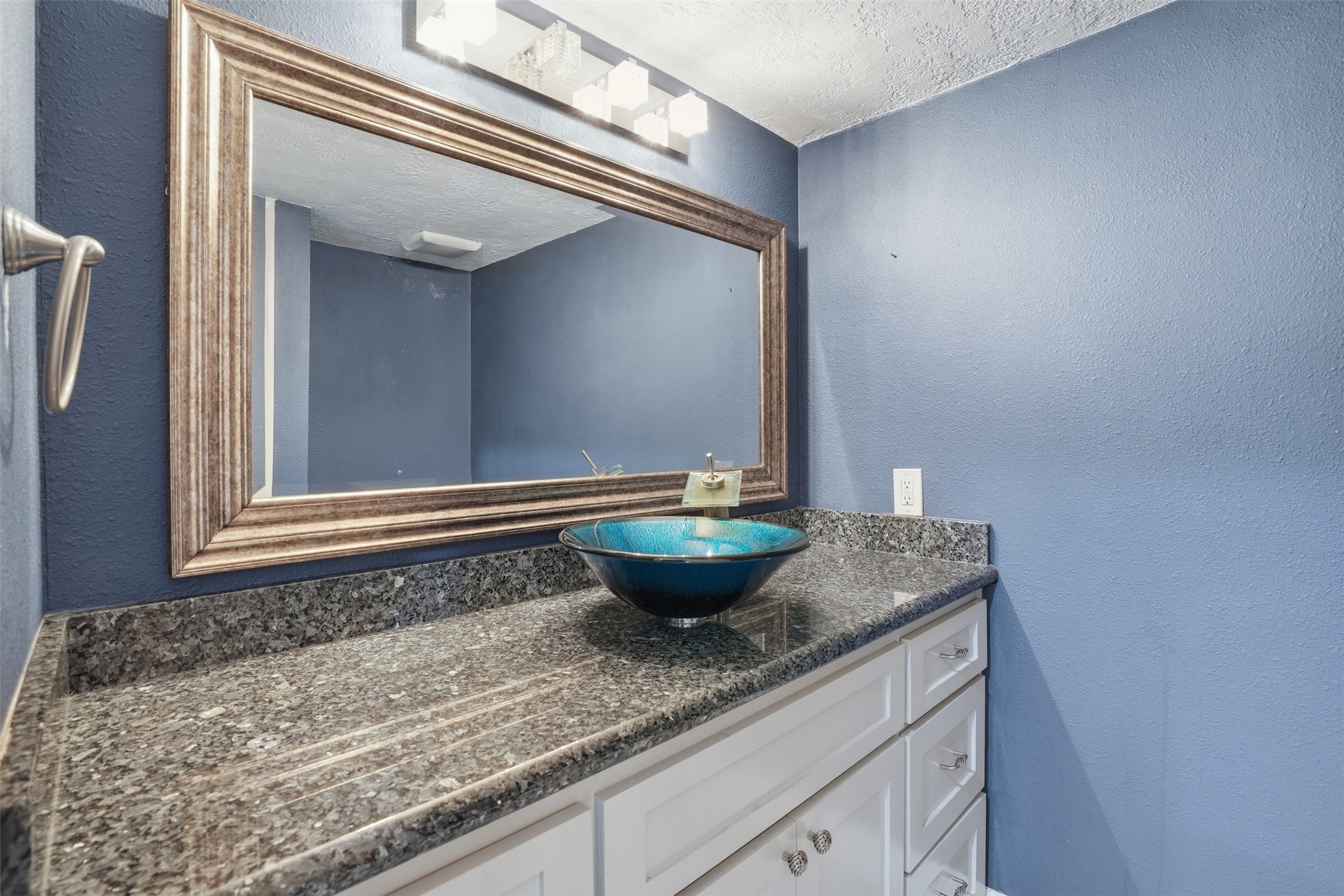 Conveniently located off the kitchen and living area, this half bath features a modern design with granite countertop and a stylish sink.