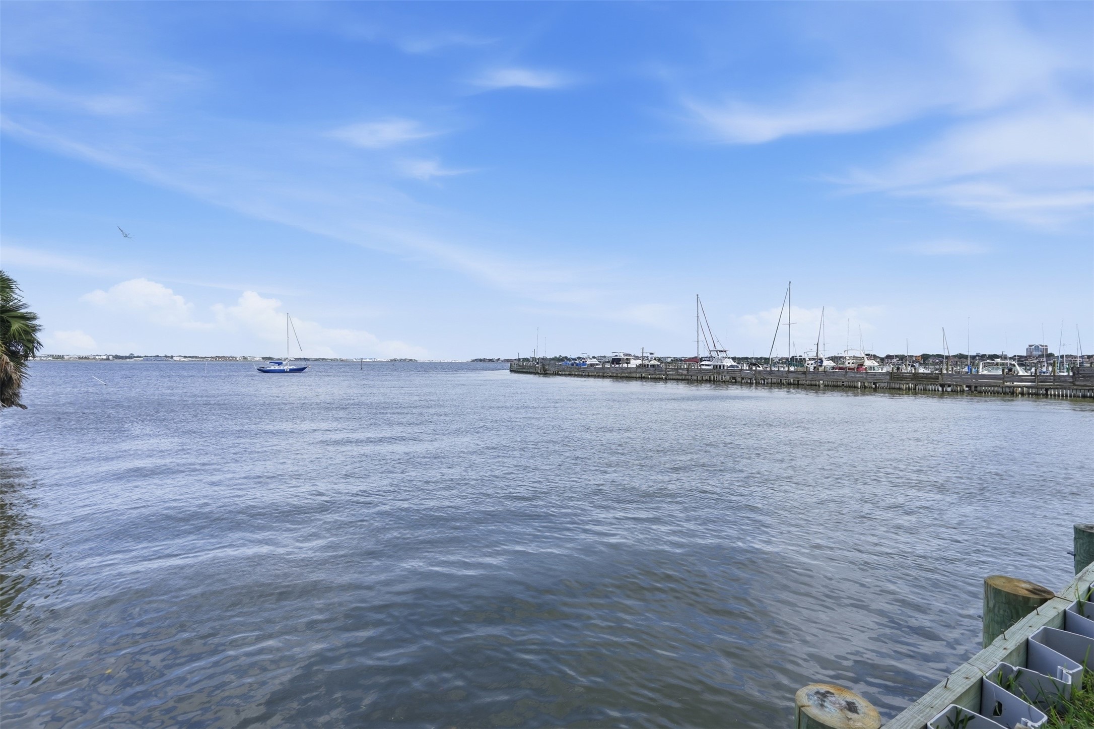 Scenic water views with calm surroundings and distant sailboats, adding to the peaceful setting of this desirable community.