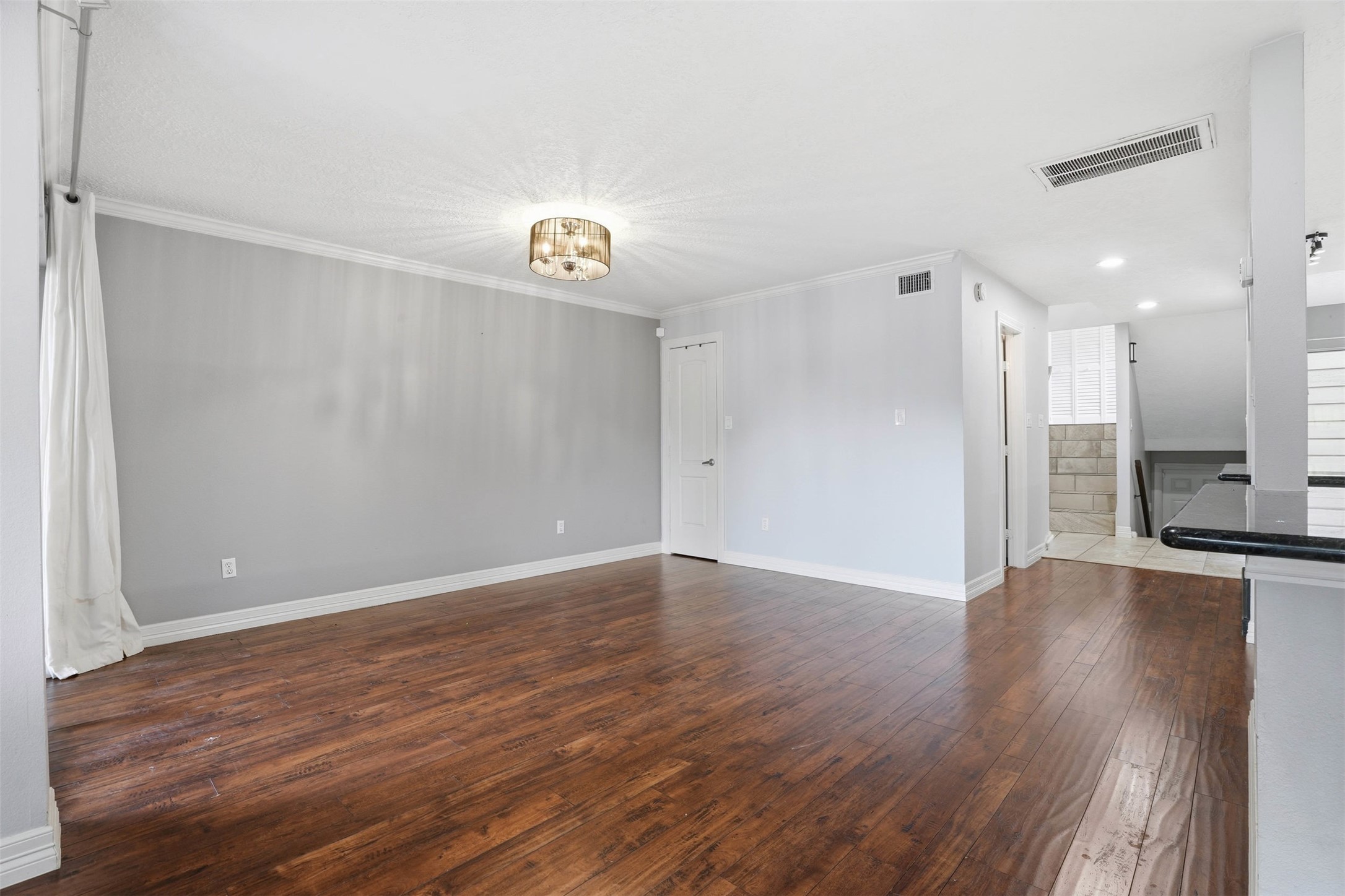 Bright and spacious dining area with hardwood floors and an open layout that connects seamlessly to the kitchen and living spaces, creating a warm and welcoming atmosphere.