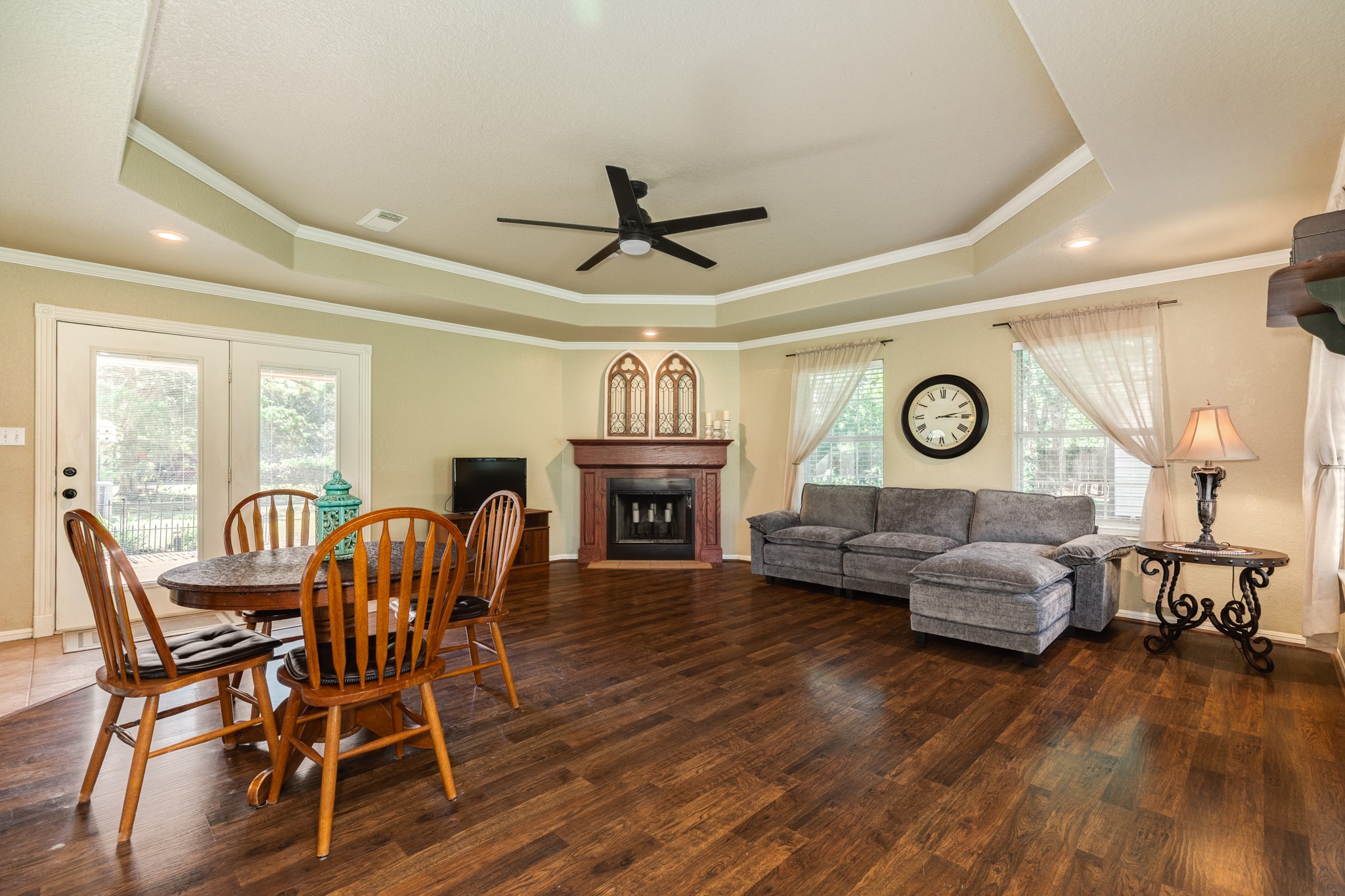 Large living room with tray ceiling and wood burning fireplace